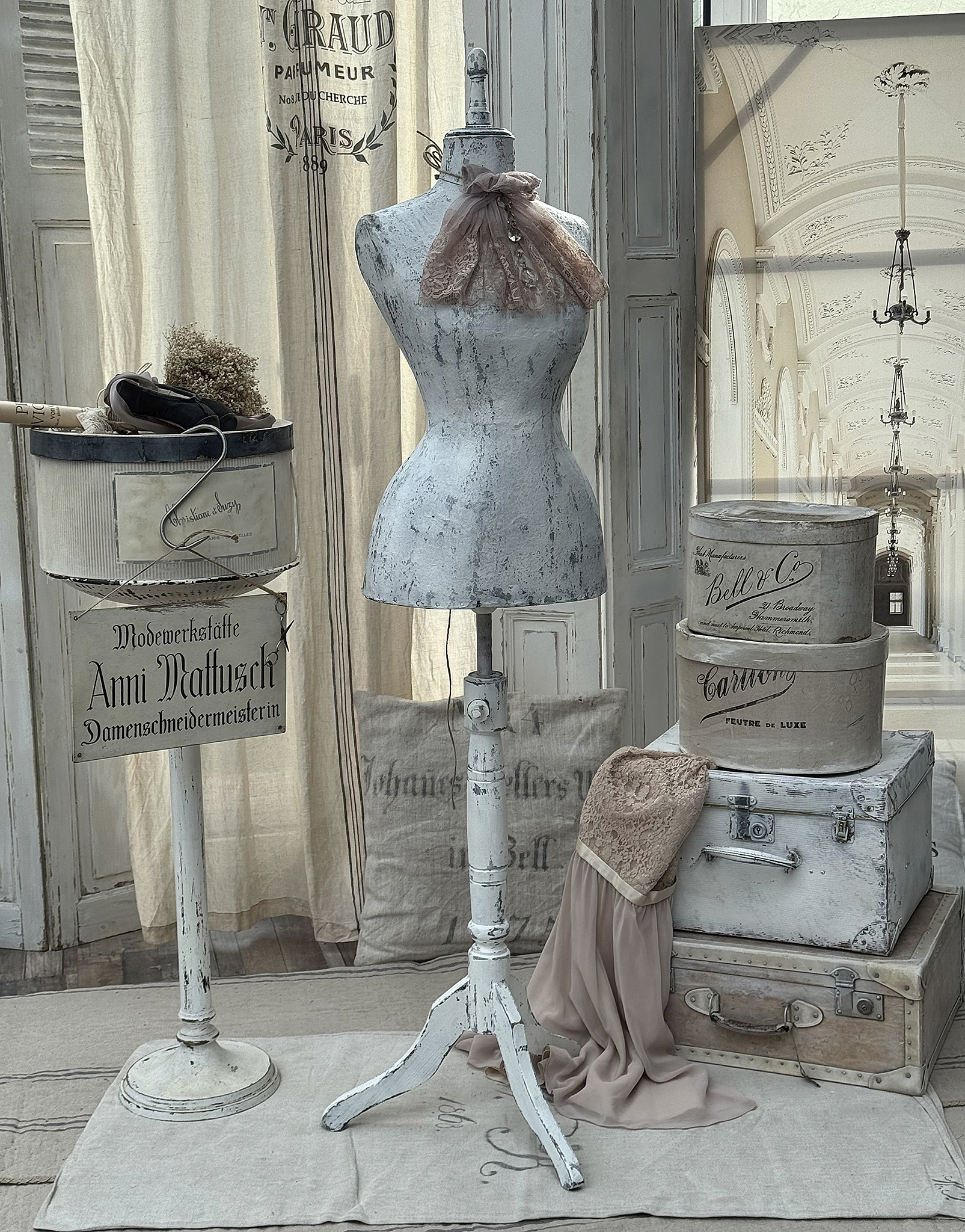 Schneiderpuppe im Vintage-Stil mit einer Spitzenschleife, stilvollen Kisten und Deko-Elementen in einem eleganten Raum