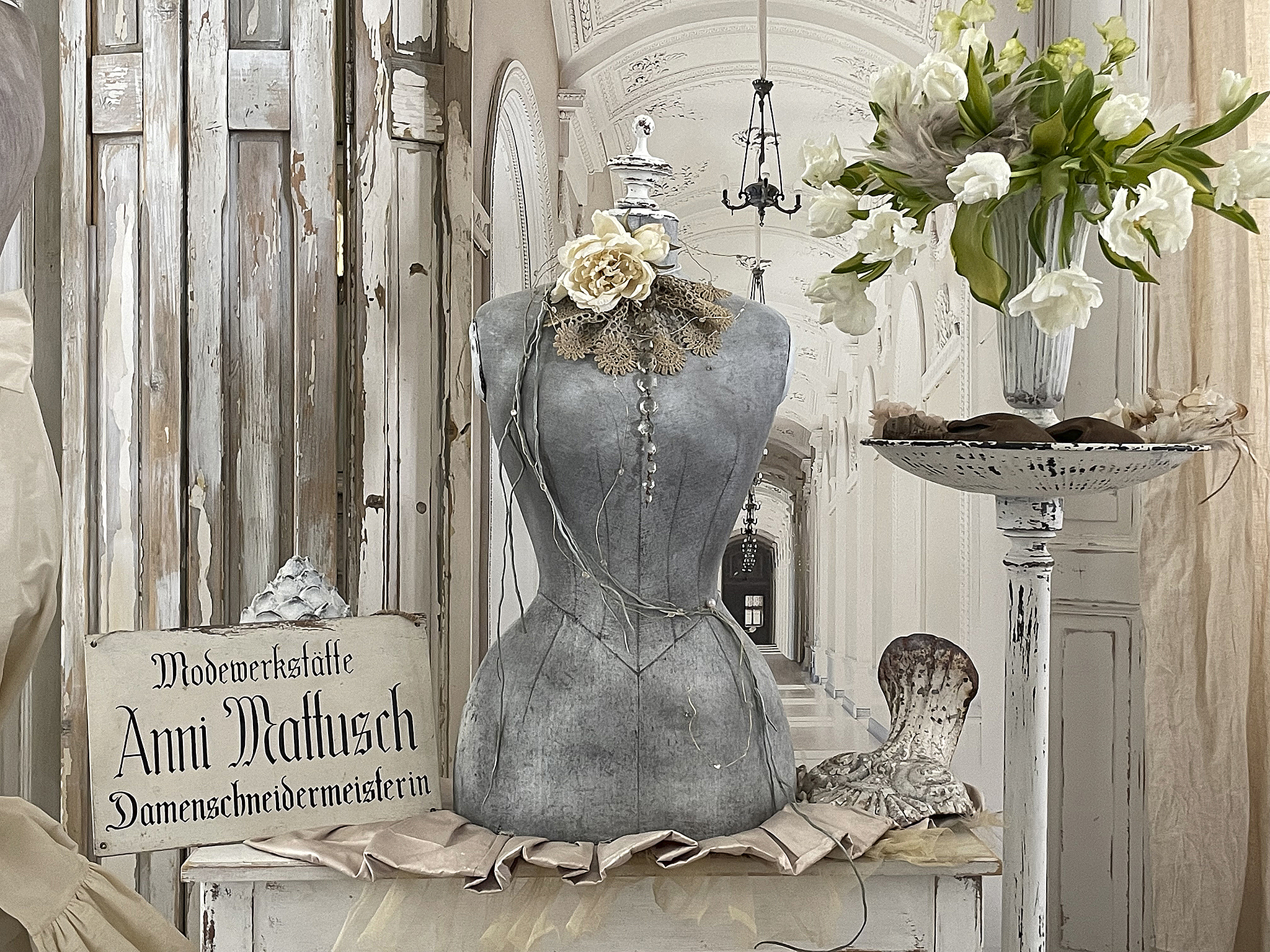 Dekoratives Interieur einer Modewerkstatt mit einer Schaufensterpuppe und einem Blumenarrangement in eleganter Umgebung.