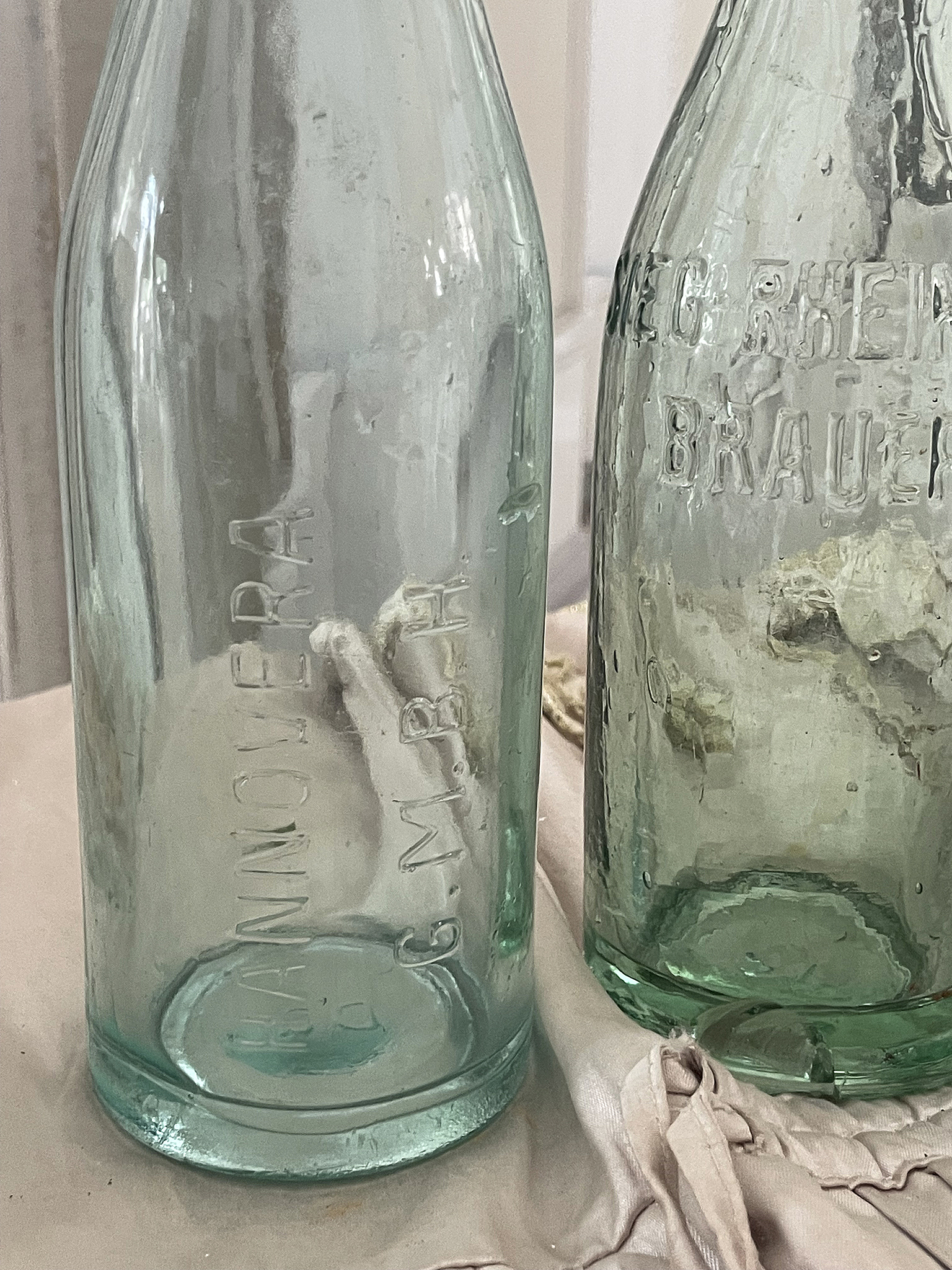 Antike Glasflaschen mit Prägung von Hannover und Brauerei Zwei antike Glasflaschen mit Prägungen, eine von Hannvoer G.M.B.H. und die andere von einer Brauerei.