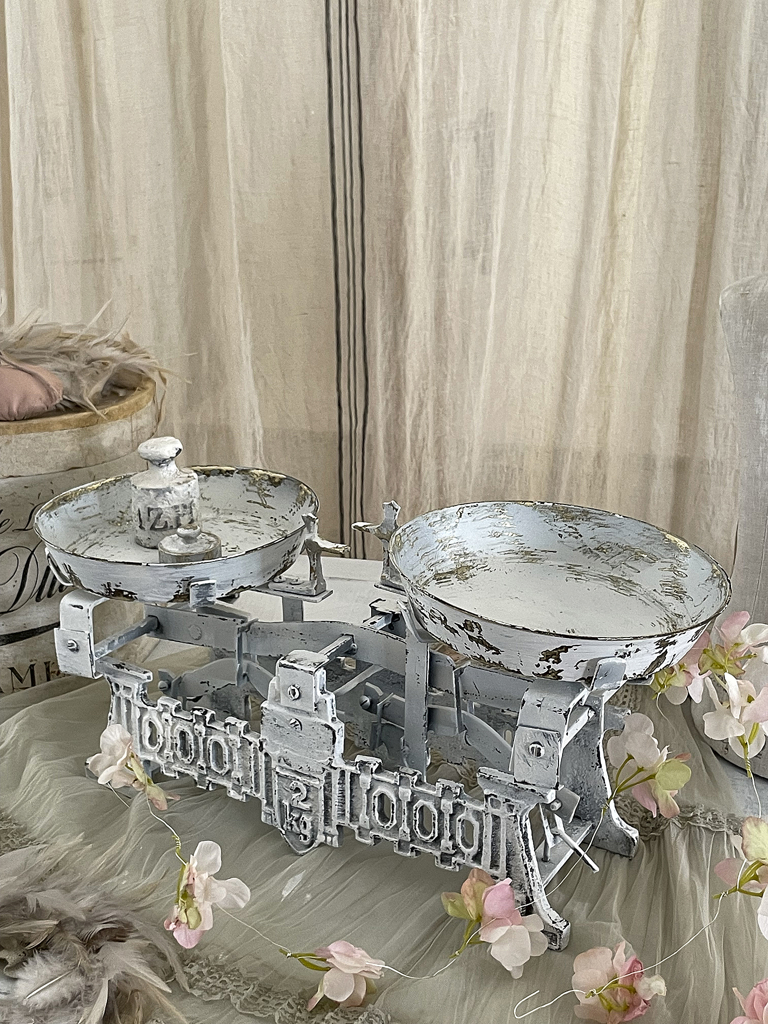 Antike Waage mit weißen Schalen und nostalgischem Charme Vintage Waage auf einem Tisch mit Blumen und sanftem Licht