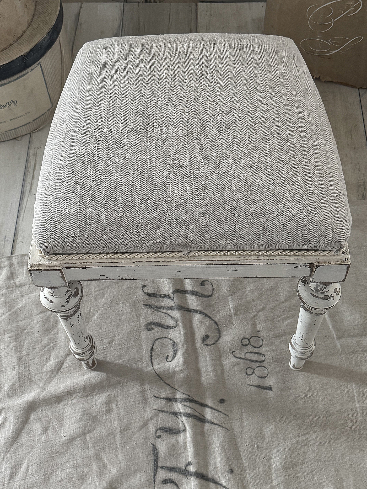  Antiker Polsterhocker mit altem Leinen***