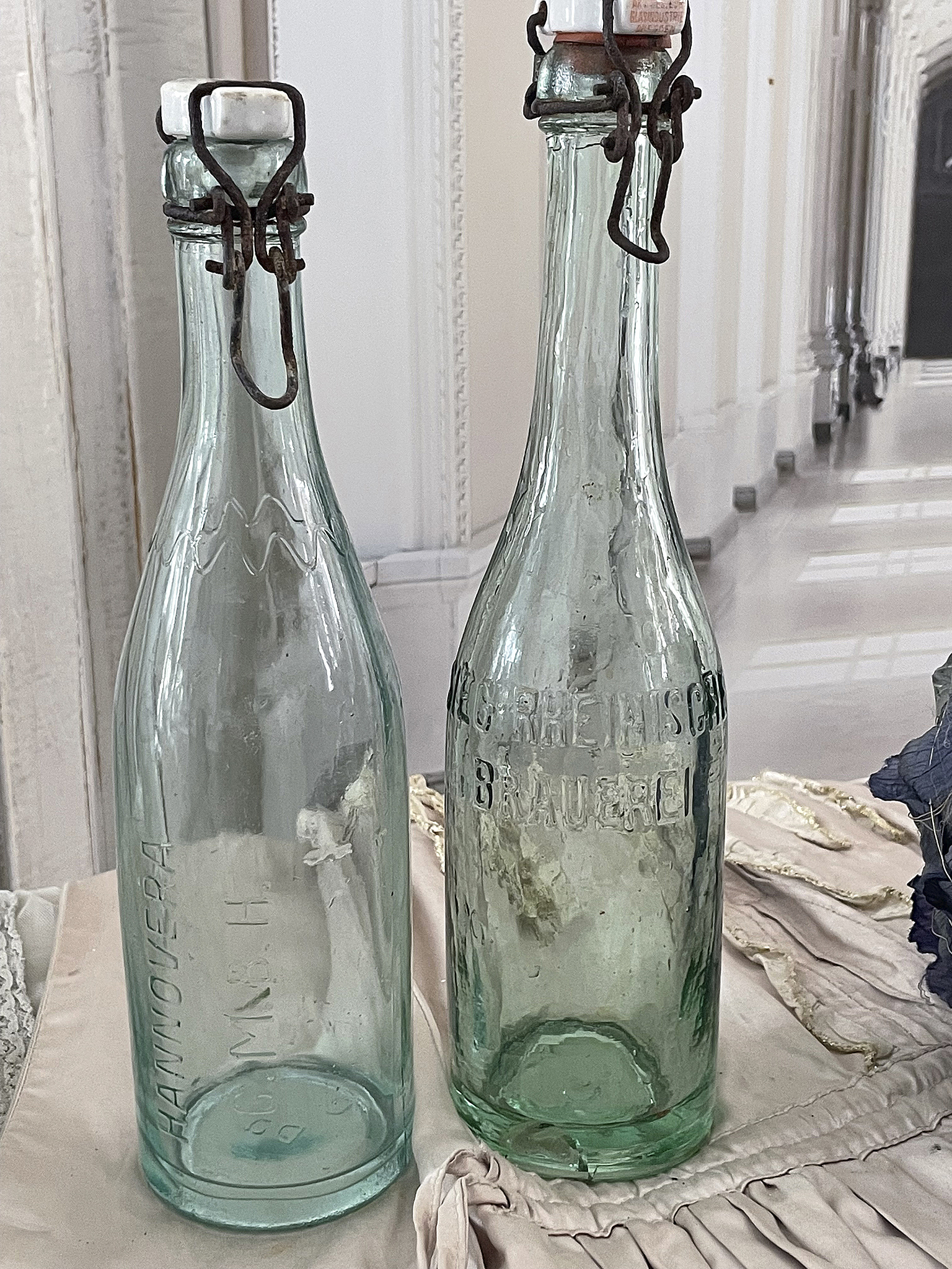 Antike Glasflaschen mit Verschluss Zwei alte Glasflaschen mit Drahtverschluss auf einem Tisch