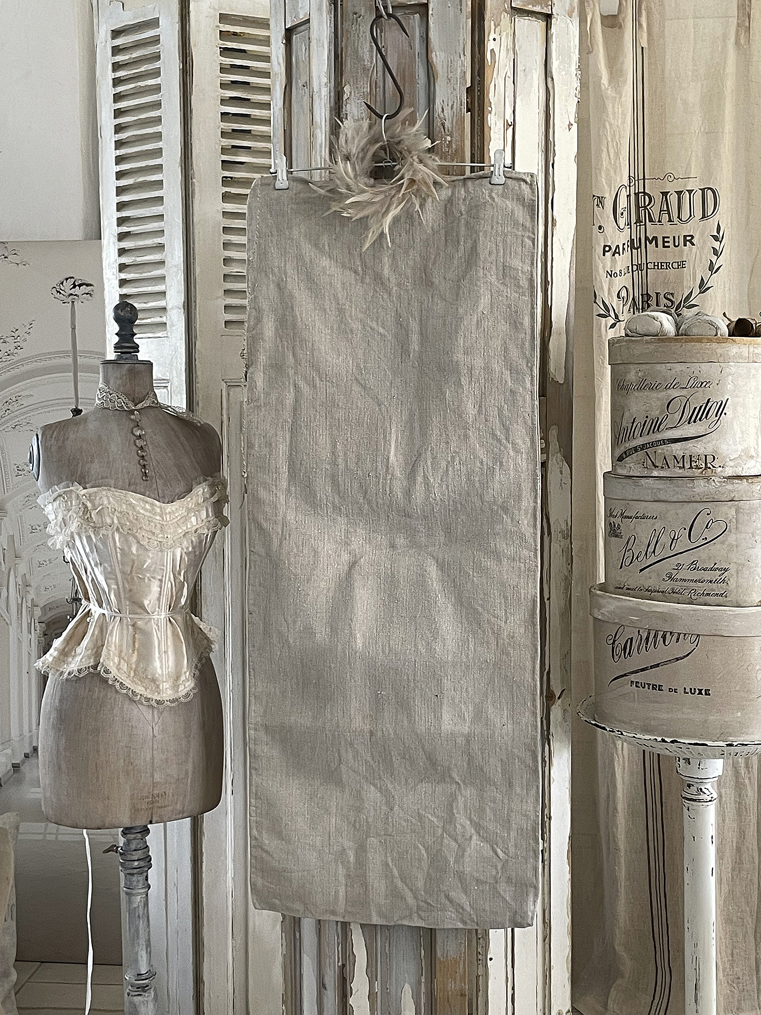 Vintage Mannequin mit eleganter Spitzenkorse und Leinenstoff im Hintergrund