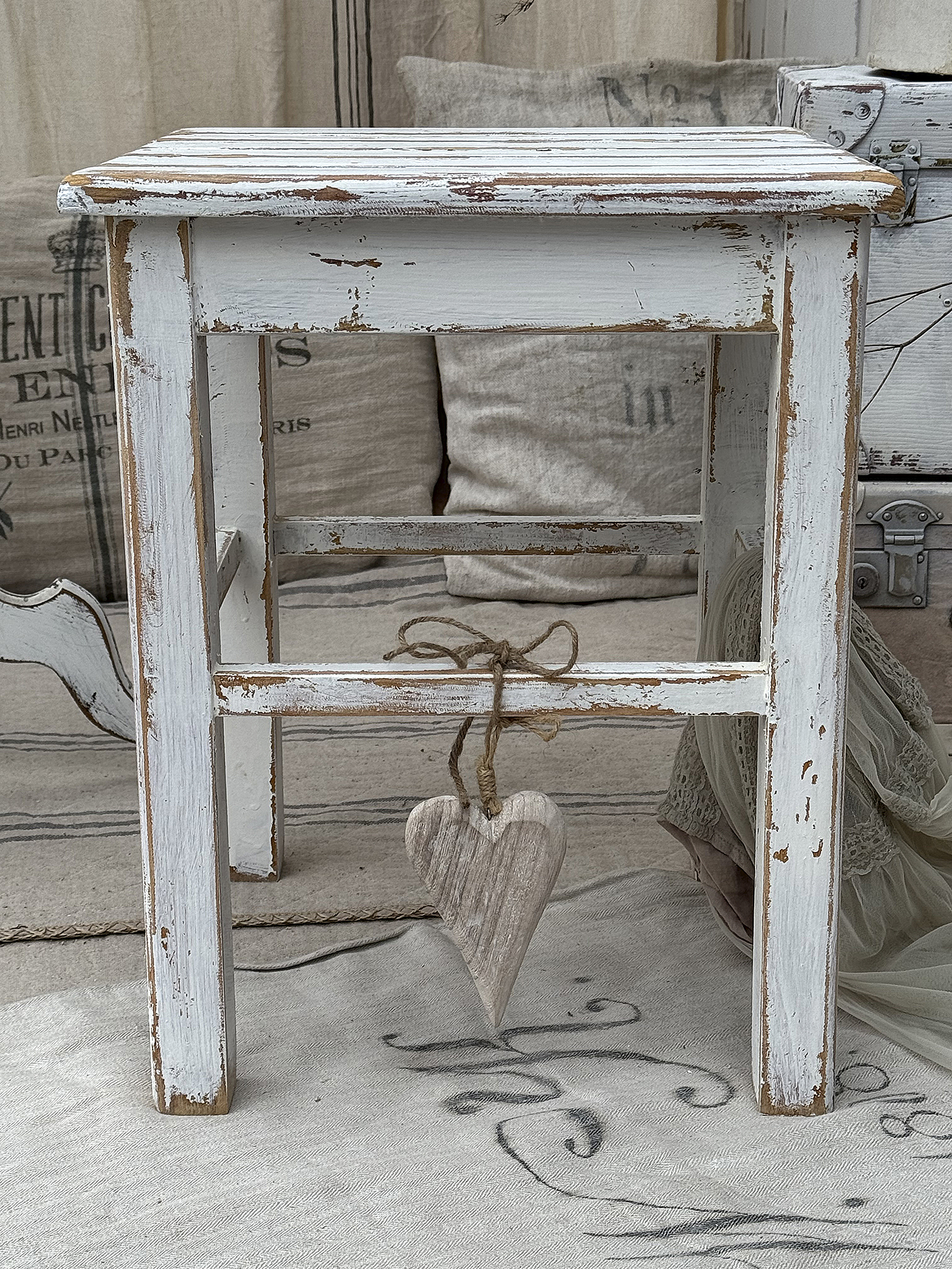 Rustikaler Holzstuhl mit Herzanhänger Holzstuhl im Shabby Chic-Stil mit einem Herzanhänger aus Holz