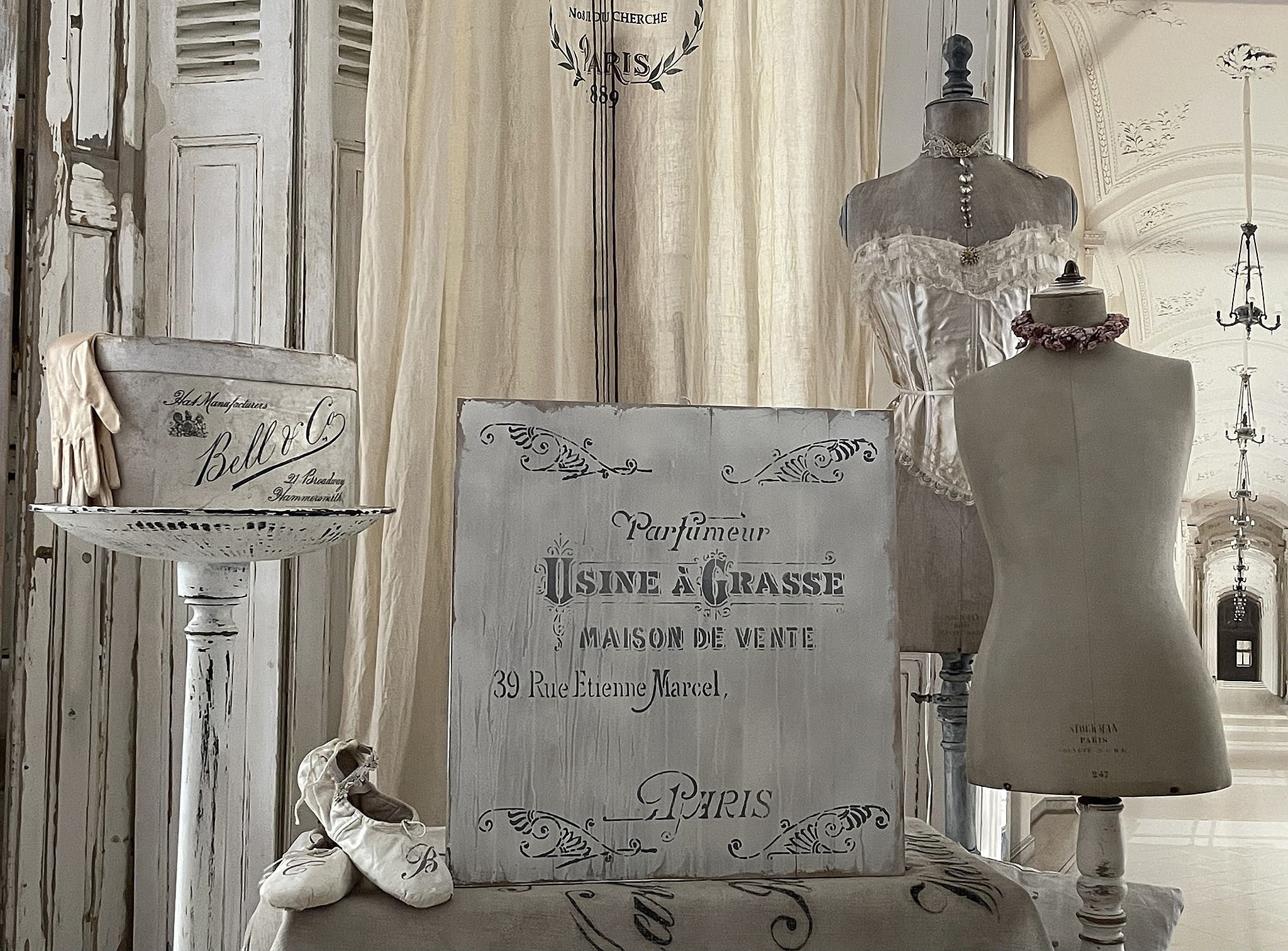 Vintage Pariser Deko mit Mannequins und historischen Accessoires Elegante Dekoration im Vintage-Stil mit Mannequins, einem Hutkasten und Ballettschuhen in einem nostalgischen Raum