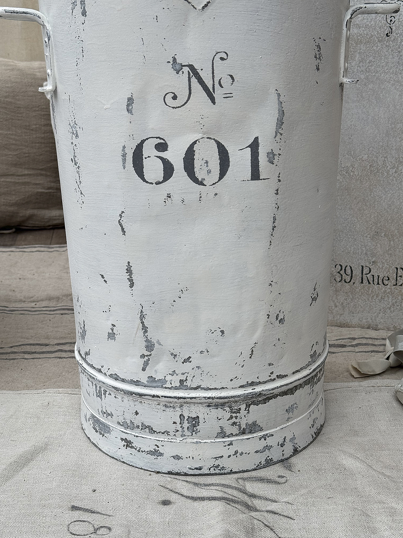 Dekorativer, antiker Eimer mit der Nummer 601 Antiker Eimer in Weiß mit der Aufschrift Nummer 601 und einem rustikalen Design
