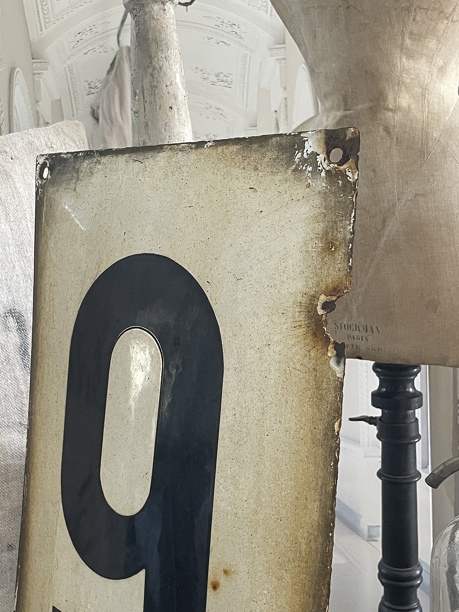 Ein altes, beschädigtes Schild mit der Zahl 9 in einem historischen Interieur.