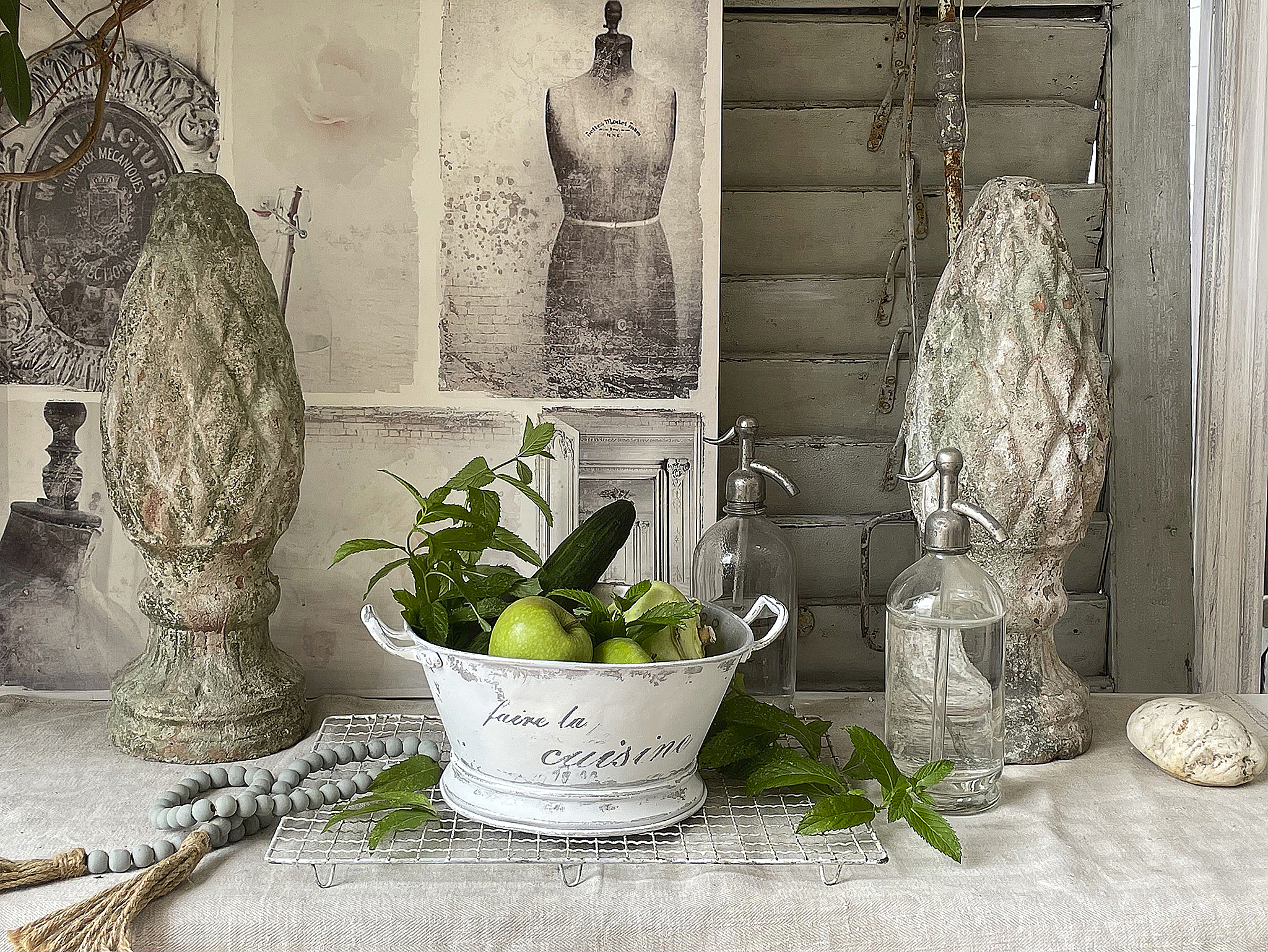 Dekorative Küchenstillleben mit frischen Zutaten und Vintage-Elementen Ein stilvolles Küchenstillleben mit einer weißen Schüssel, frischen Äpfeln und Gurken, umgeben von dekorativen Vasen und Vintage-Deko.