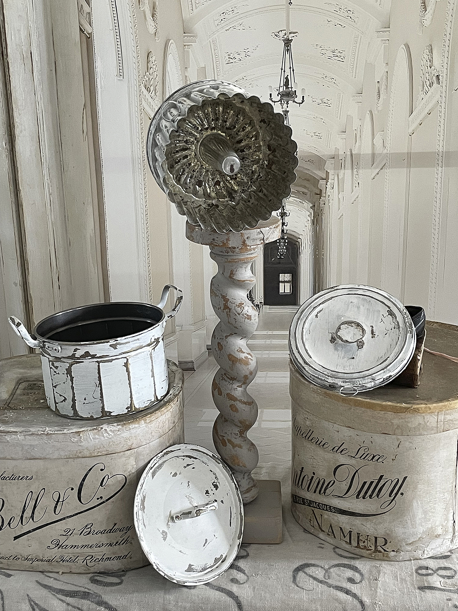 Vintage Dekoration mit Metallformen und antiken Behältern Antike Metallformen und weiße Behälter auf einem eleganten Boden in einem historischen Raum