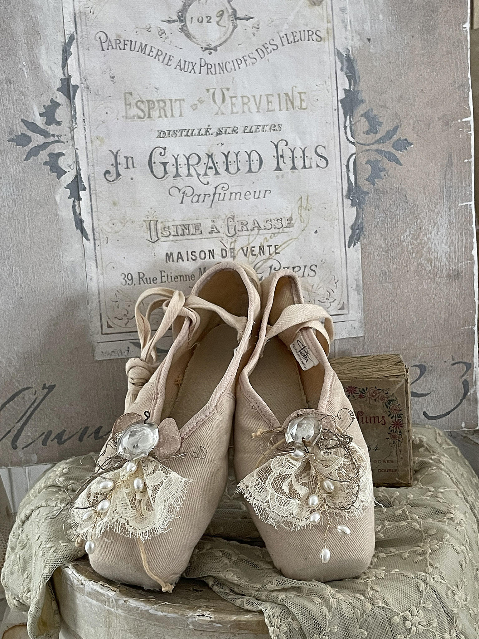 Vintage Ballettschuhe mit dekorativer Spitze und Perlen Balletschuhe im Vintage-Stil mit hochwertigen Details, darunter Spitze und Perlen, vor einer nostalgischen Hintergrundtapete.