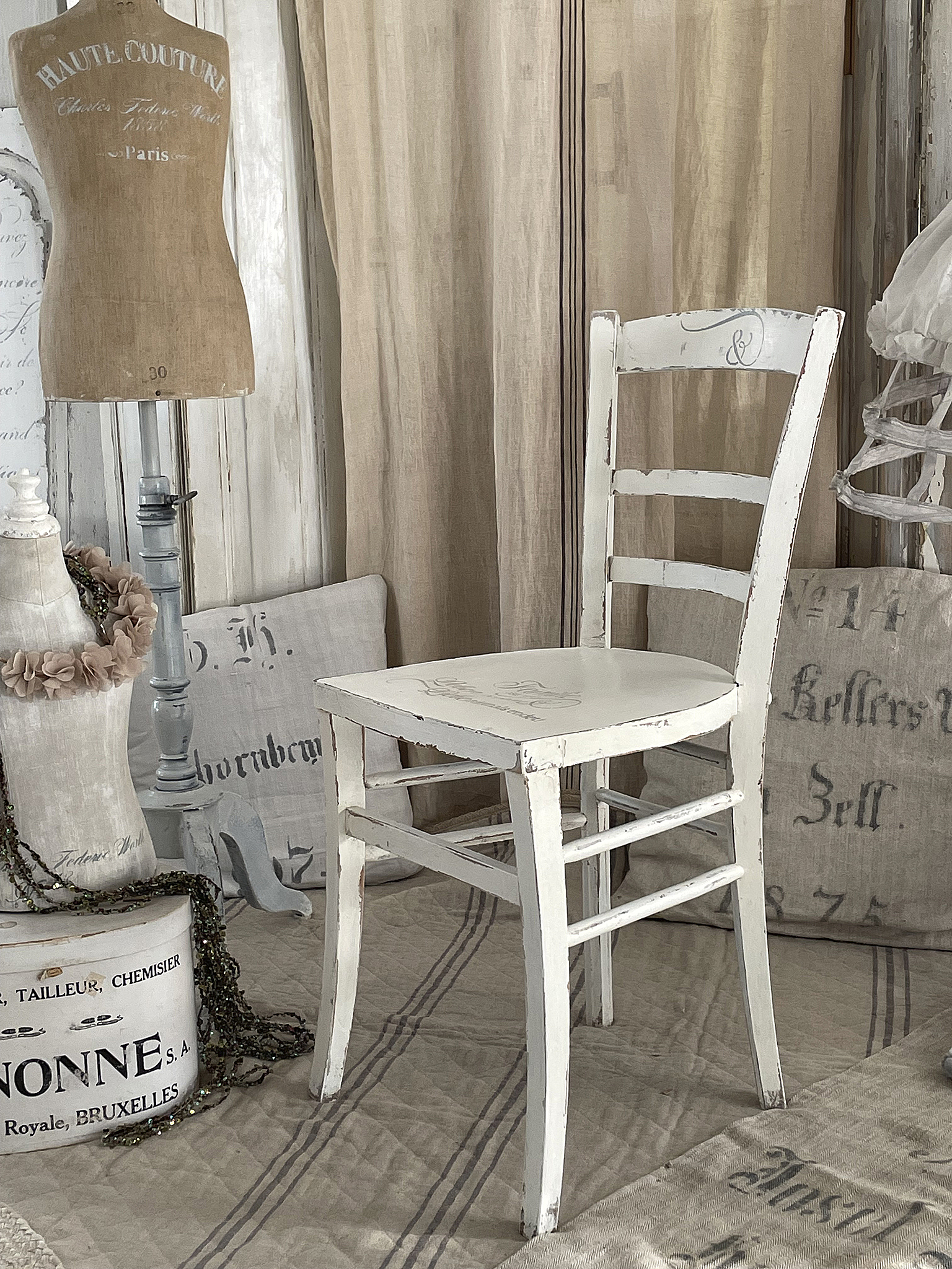Weißer Holzstuhl im Vintage-Stil mit Dekoration Ein eleganter weißer Holzstuhl im Vintage-Stil, umgeben von stilvollen Accessoires und Dekorationen.