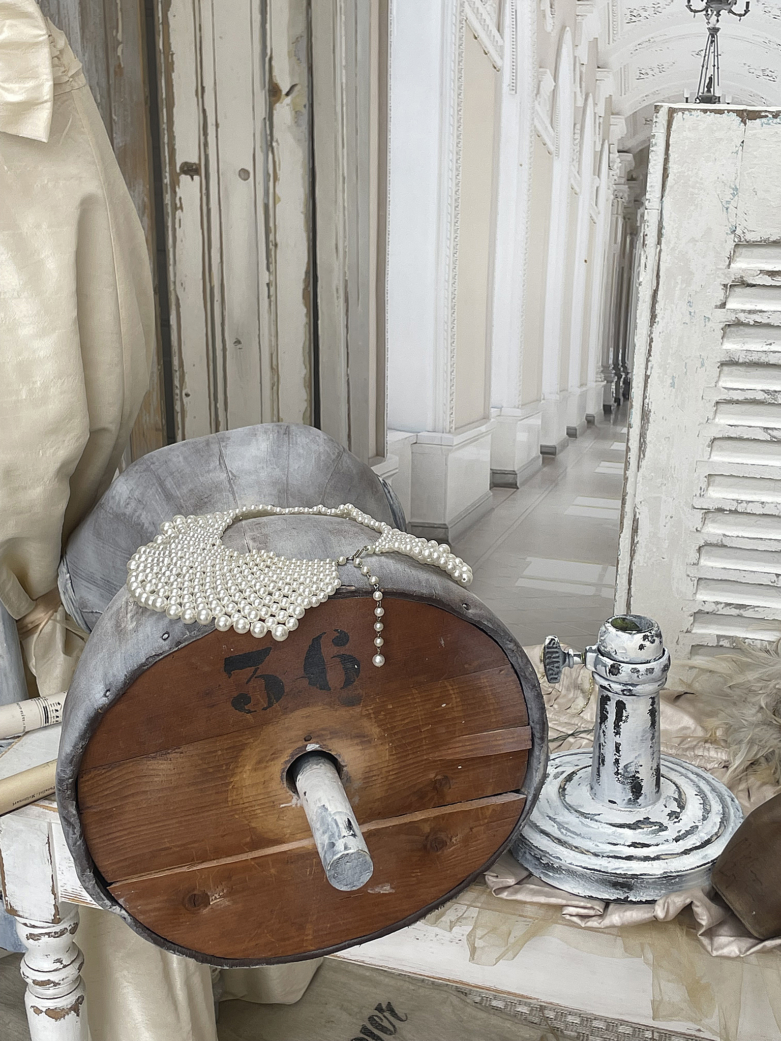 Vintage Dekoration mit Holzfass und Perlenkette Detailansicht eines Holzfasses mit der Nummer 36 und einer Perlenkette, daneben ein dekoratives Element in einem hellen Raum