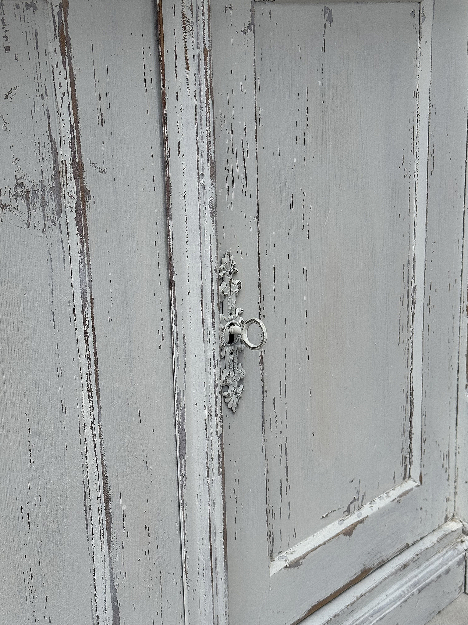 Antiker Schrank mit schöner Türverzierung Detailaufnahme eines antiken Schranks mit silbernem Türschloss und patinierter Oberfläche