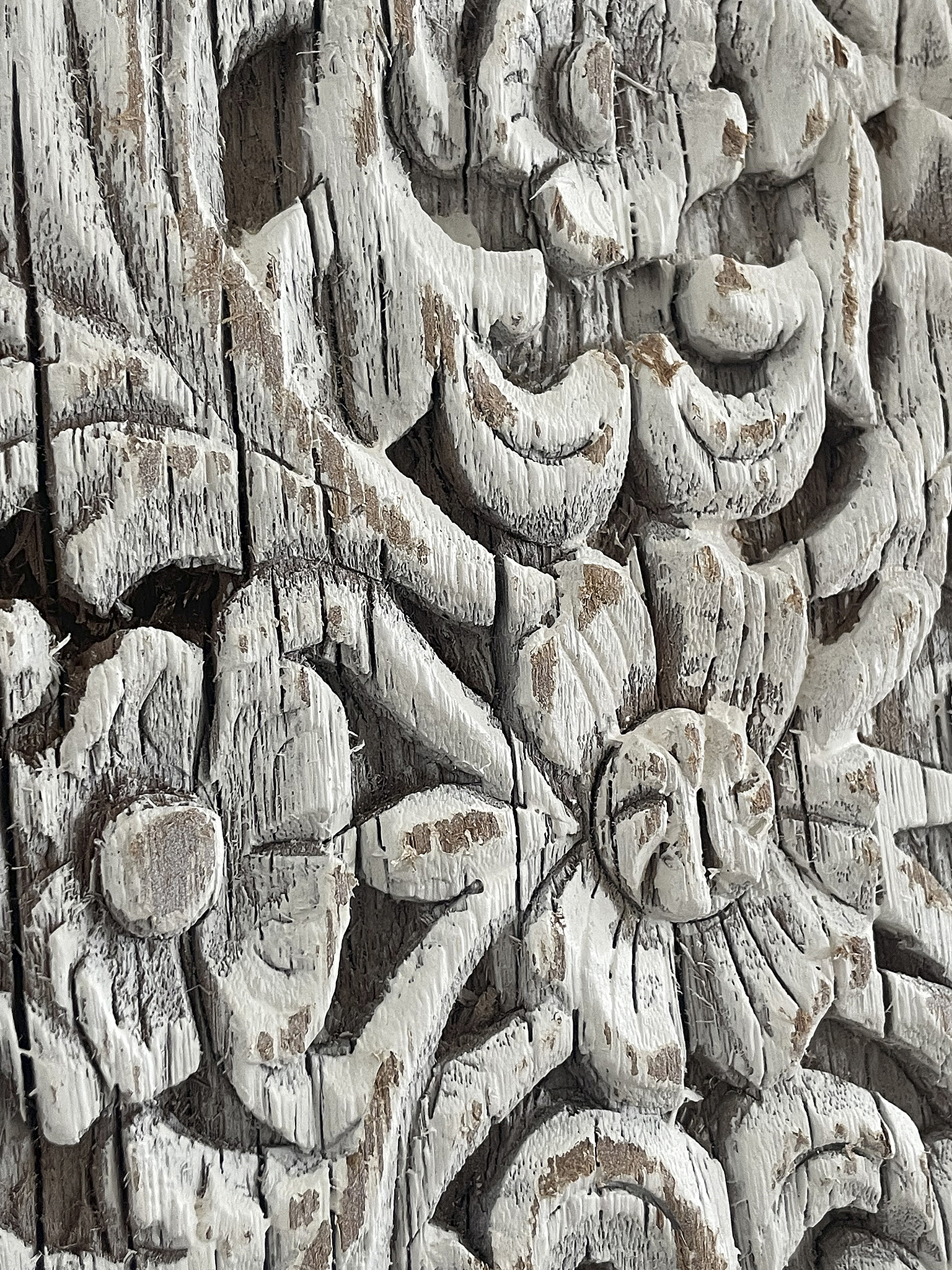 Detailaufnahme von kunstvoll geschnitztem Holz mit floralem Muster Kunstvoll geschnitztes Holz mit floralen Motiven in Weiß und Grau