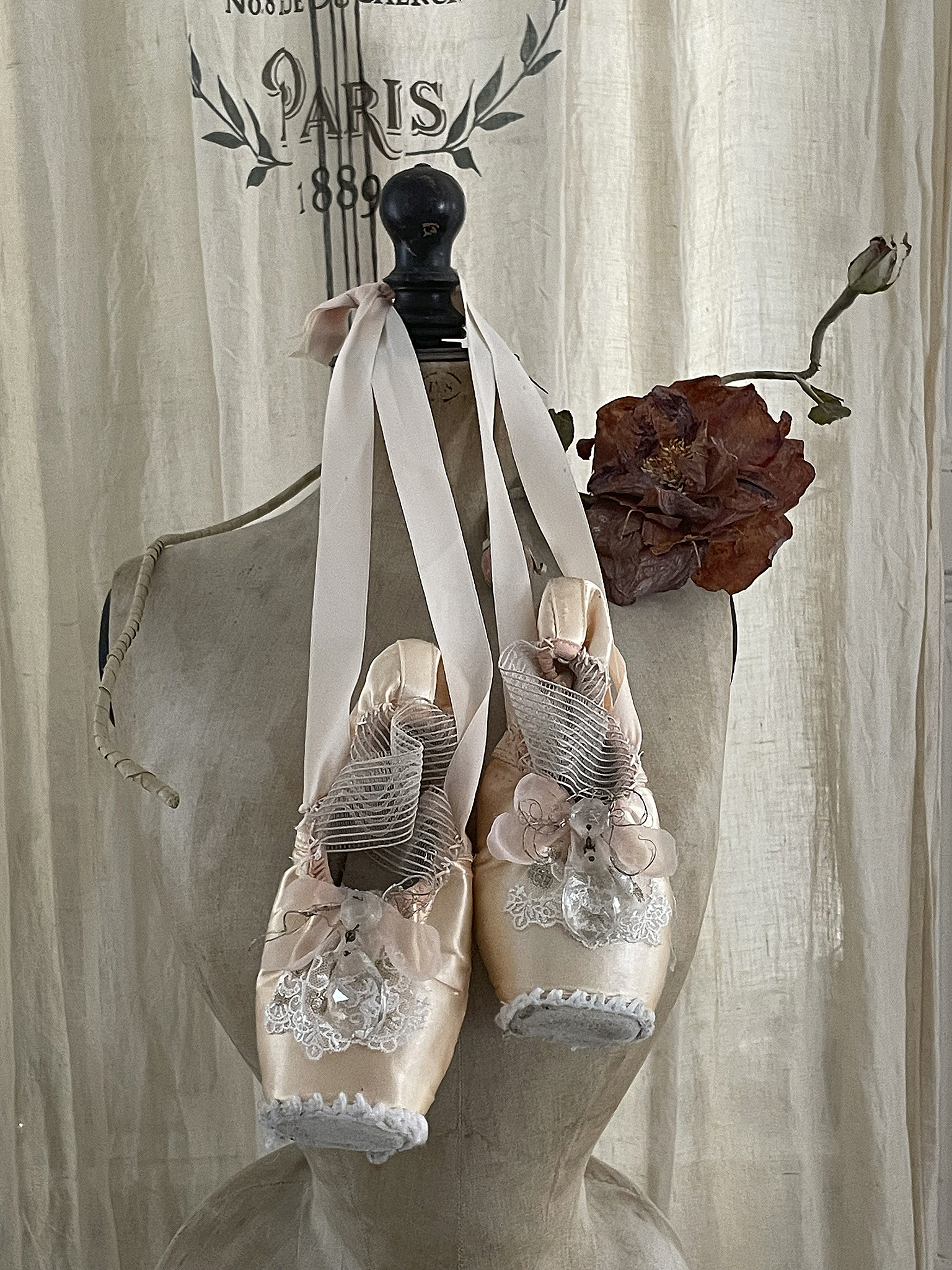 Elegante Ballettschuhe mit schönen Verzierungen Schöne Ballettschuhe, dekoriert mit Bändern und Blumen auf einem Schaufensterständer