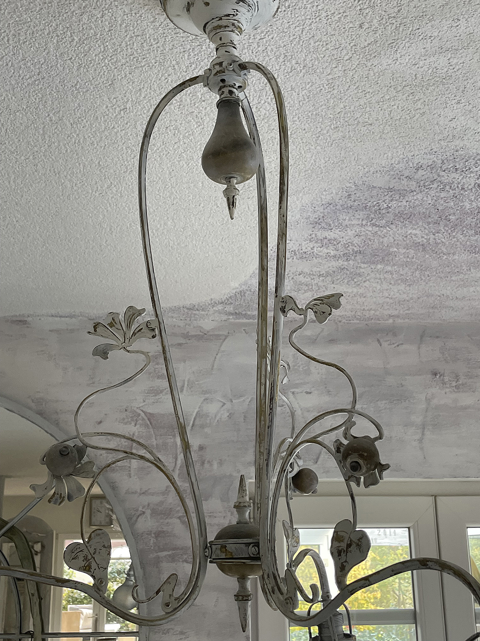 Antike Deckenleuchte mit filigranem Design und Patina Detailansicht einer antiken Deckenleuchte mit schmiedeeisernen Verzierungen und einer rustikalen Oberfläche