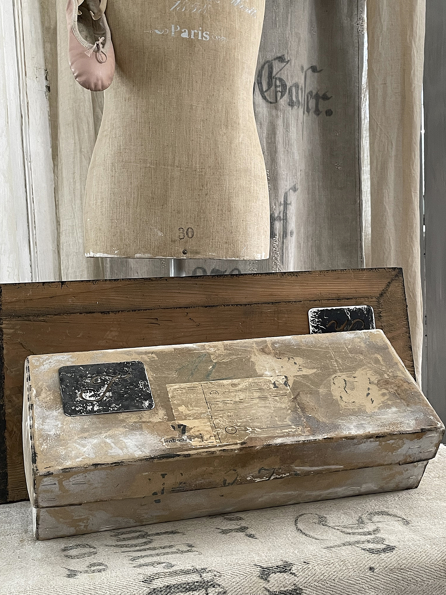 Vintage Mannequin mit Tanzschuh und altem Koffer Detailaufnahme eines Vintage-Mannequins mit einem rosa Tanzschuh sowie einem alten Koffer im Hintergrund