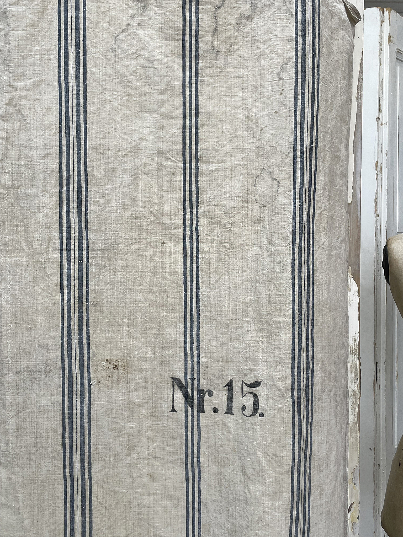 Stoff mit blauen Streifen und der Aufschrift Nr. 15 Nahaufnahme eines weißen Stoffes mit blauen Streifen und der Nummer 15.