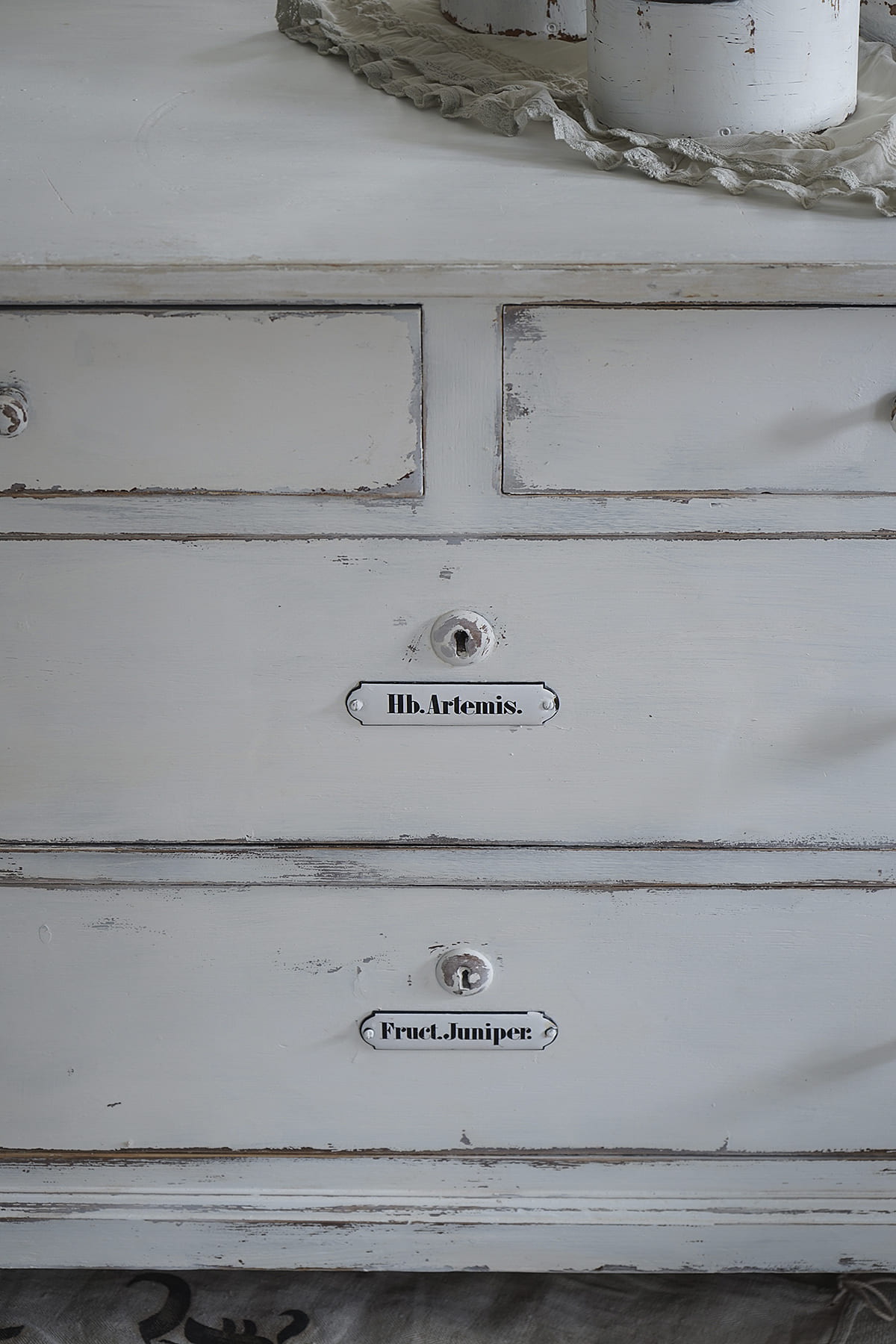 Vintage Kommode mit Beschriftungen von Hb. Artemis und Fruct. Juniper Detailansicht einer alten Kommode mit klassischer Beschriftung, die die Namen Hb. Artemis und Fruct. Juniper zeigt.