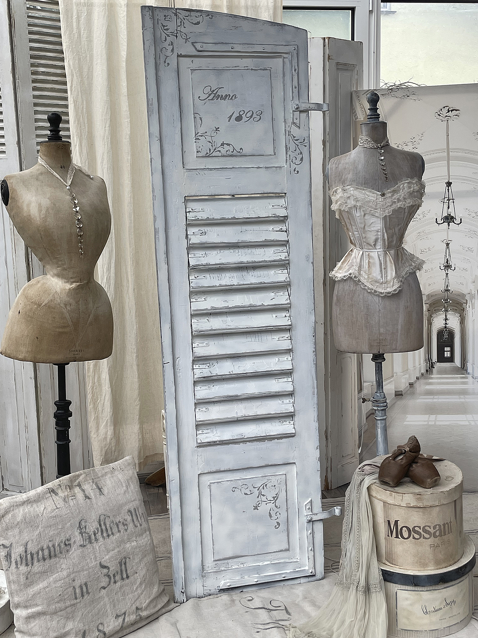 Vintage Dekoration mit Mannequins, einer antiken Tür und nostalgischen Accessoires Stilvolle Vintage-Dekoration mit Mannequins, einer historischen Tür aus dem Jahr 1893 und dekorativen Objekten.