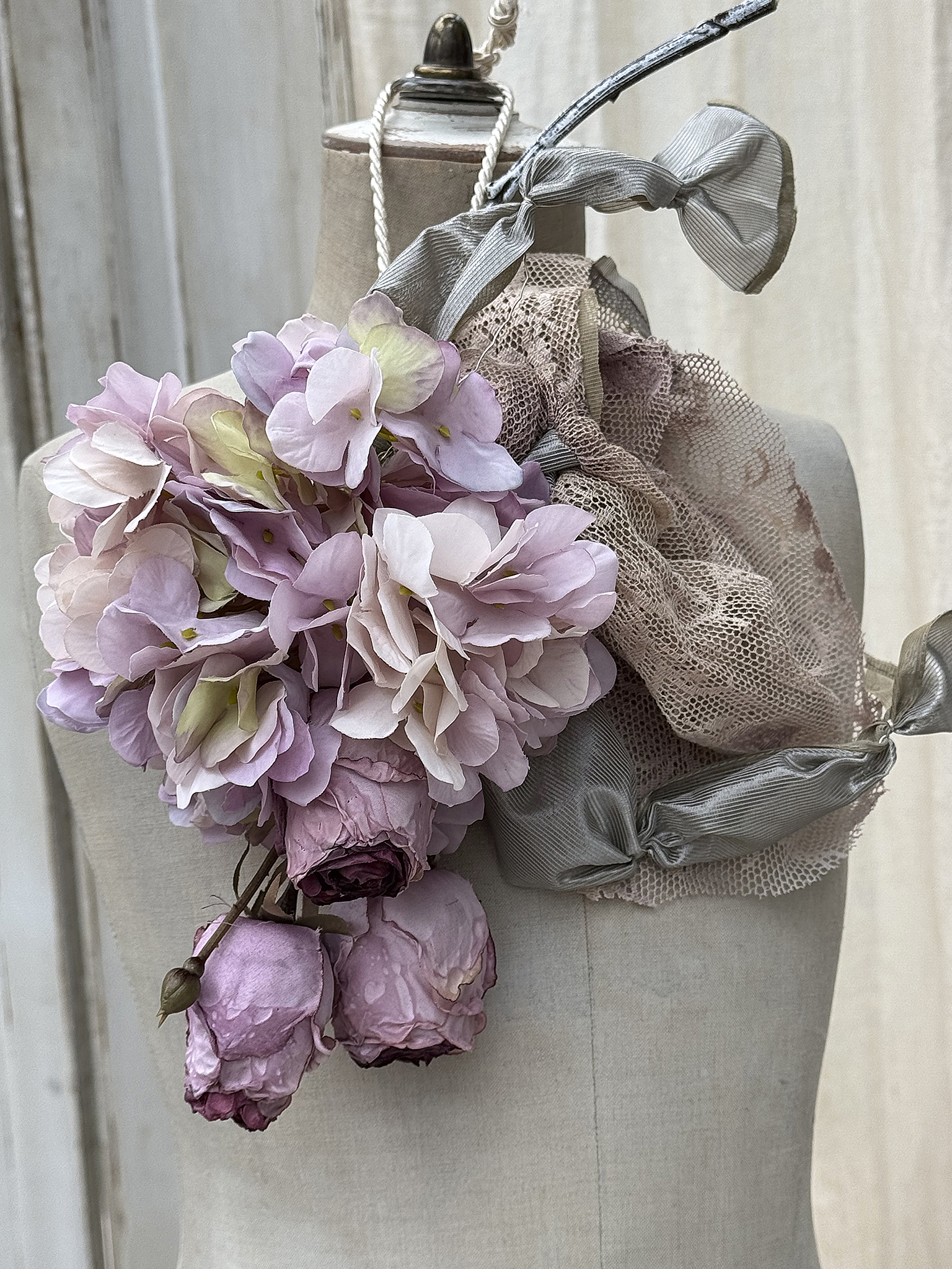 Blumenbouquet aus rosa und lilafarbenen Trockenblumen auf einer Schneiderpuppe