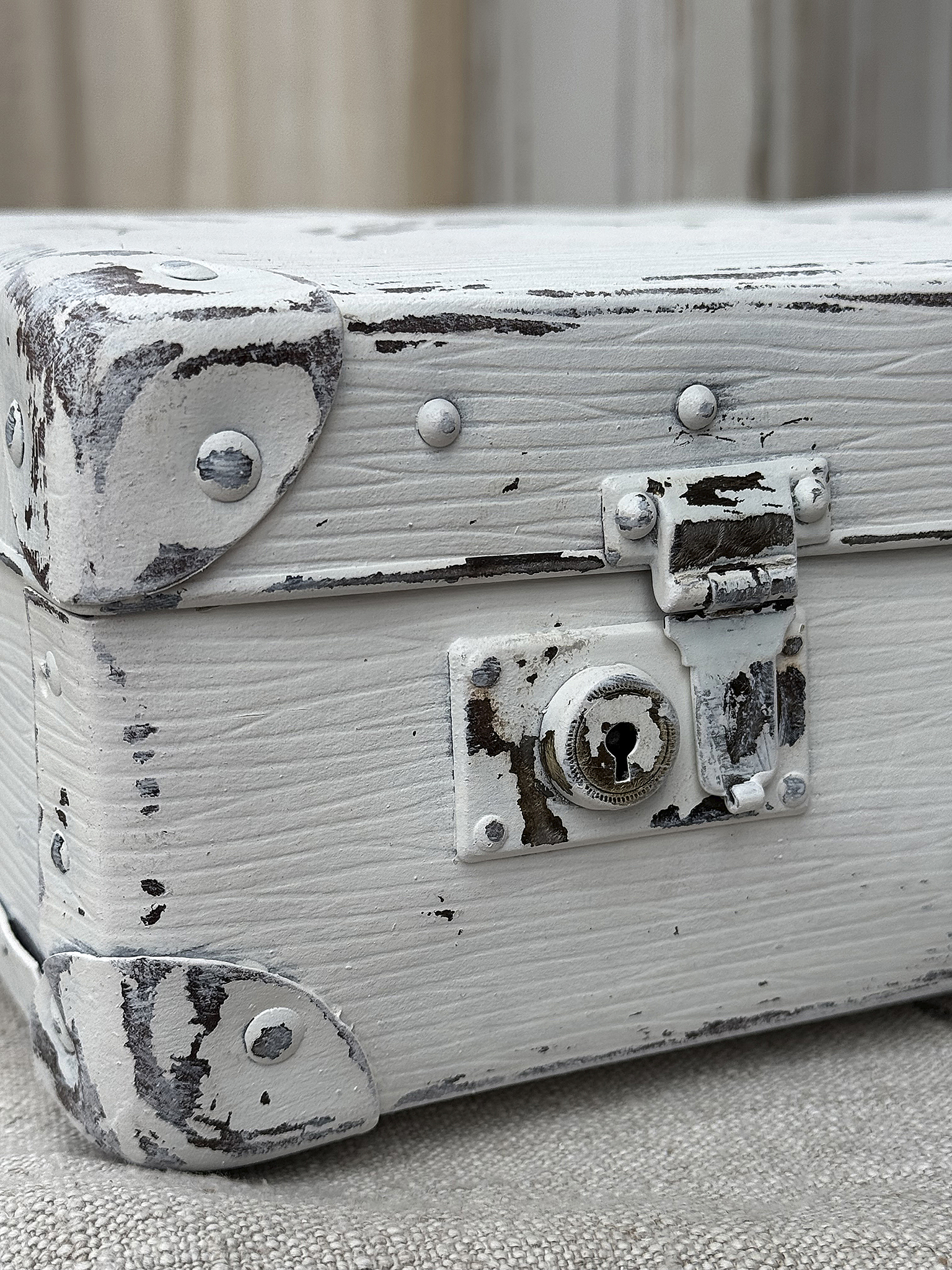Vintage Koffer in weiß mit Shabby-Chic-Look Detailansicht eines alten weißen Koffers mit abgeblätterter Farbe und Schloss