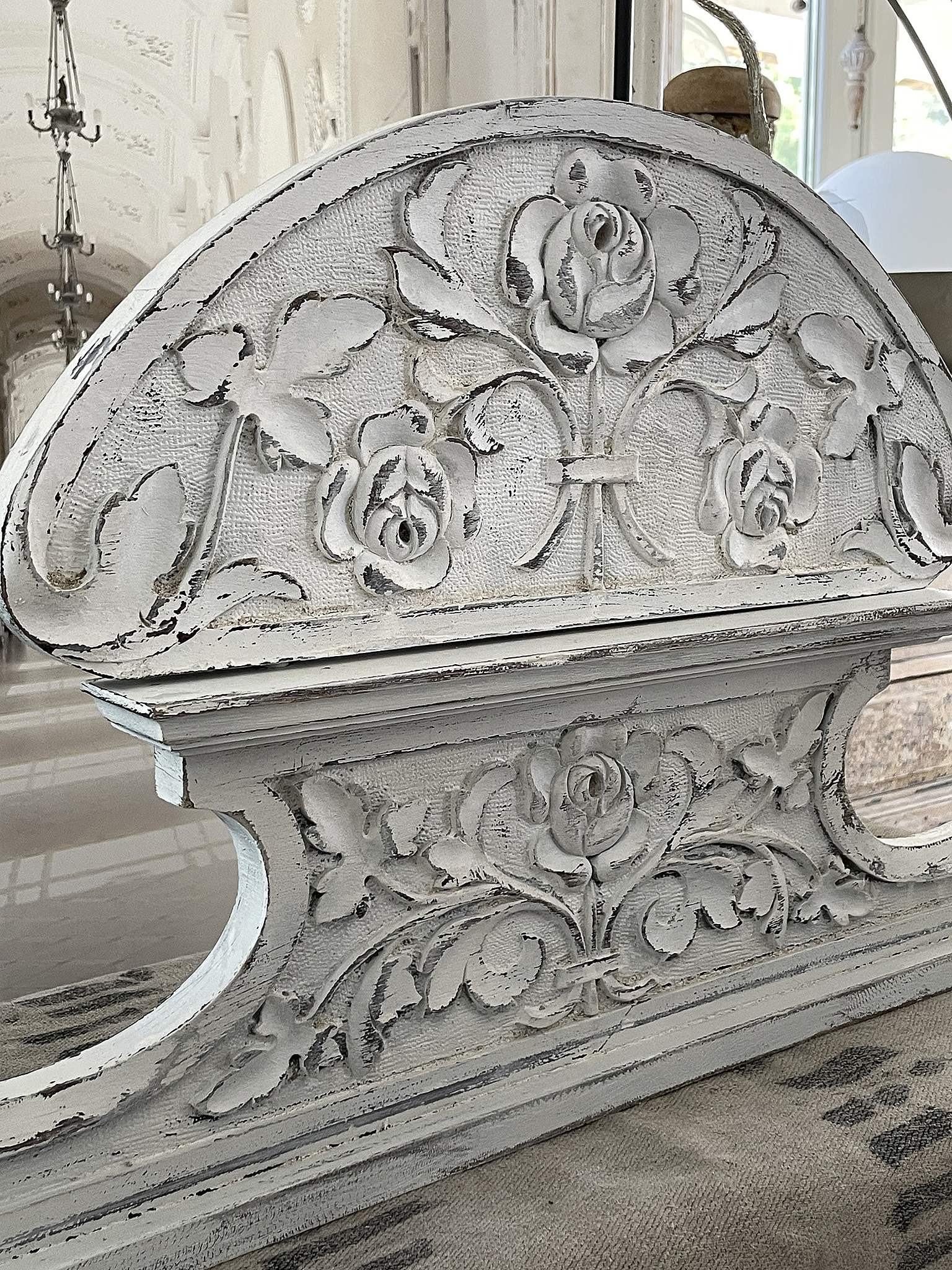 Dekorativer Holzaufsatz mit Blumenmotiven in Weiß Detailaufnahme eines verzierten Holzaufsatzes mit floralen Schnitzereien in Weiß