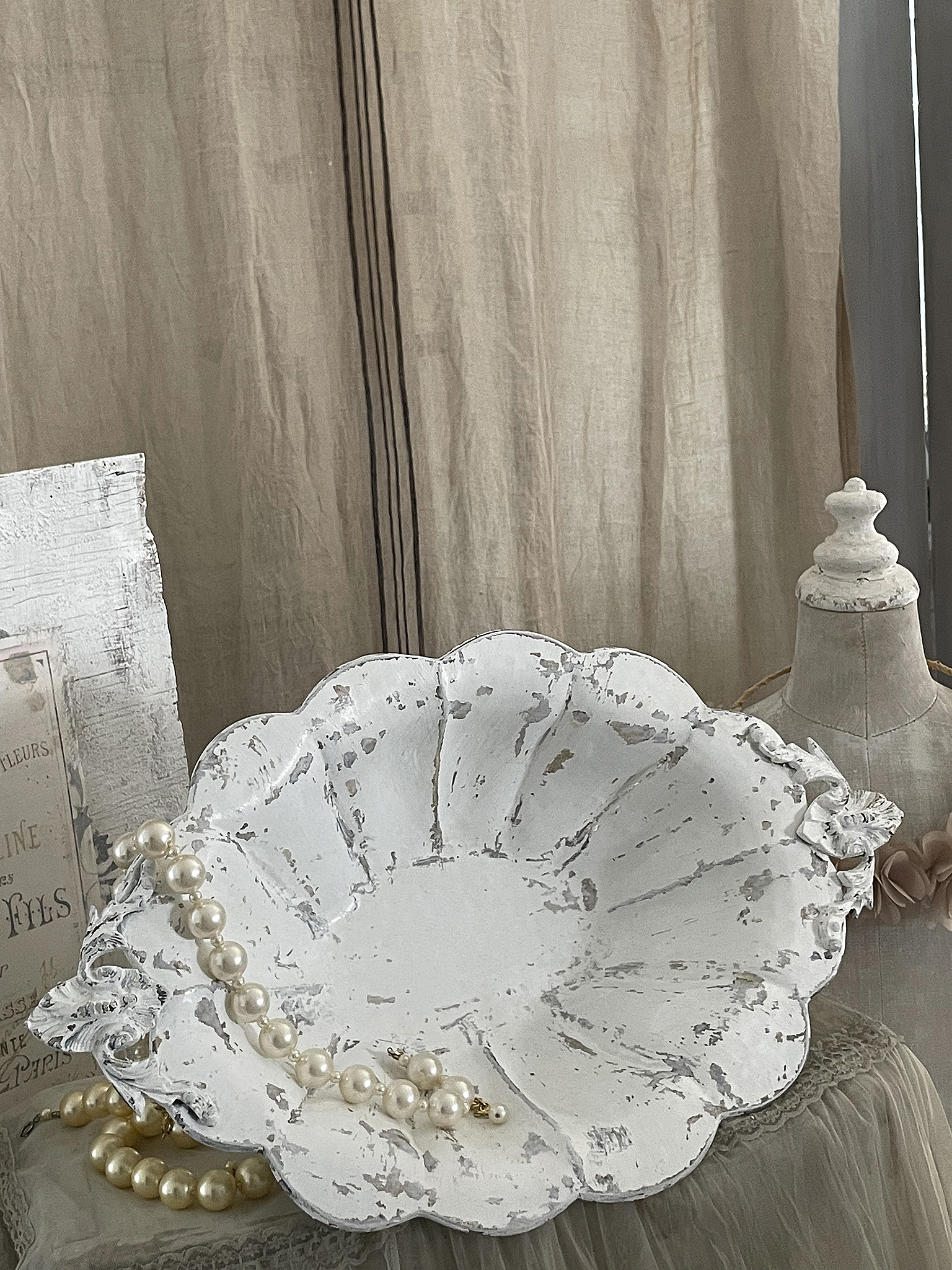 Schöne dekorative Schale mit Perlen auf einem Tisch Dekorative Schale in Weiß mit vintage Look und Perlenkette, schön arrangiert auf einem Tisch