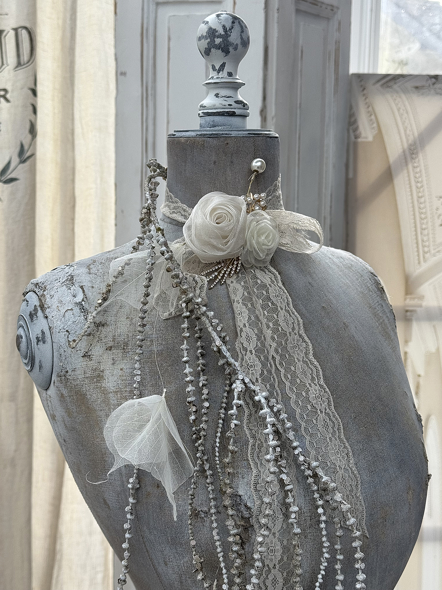 Elegantes Mannequin mit Couture-Dekoration Mannequin mit weißen Rosen, Spitze und Perlenschmuck in stilvollem Setting