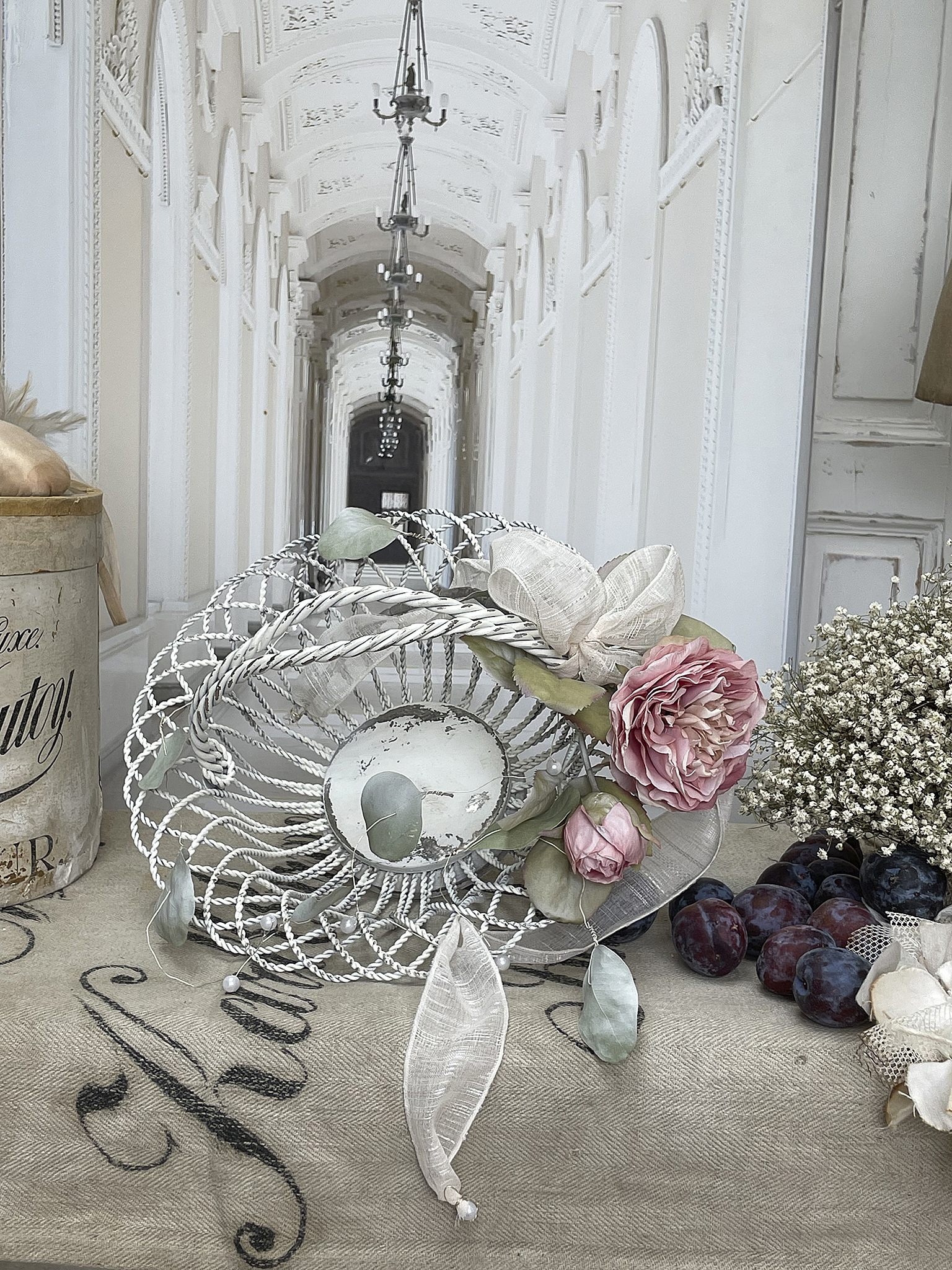 Dekorative Schale mit Rosen und Frühlingsblumen Dekorative Schale auf Tisch mit rosa Rosen, Beeren und Frühlingsblumen in einem eleganten Ambiente