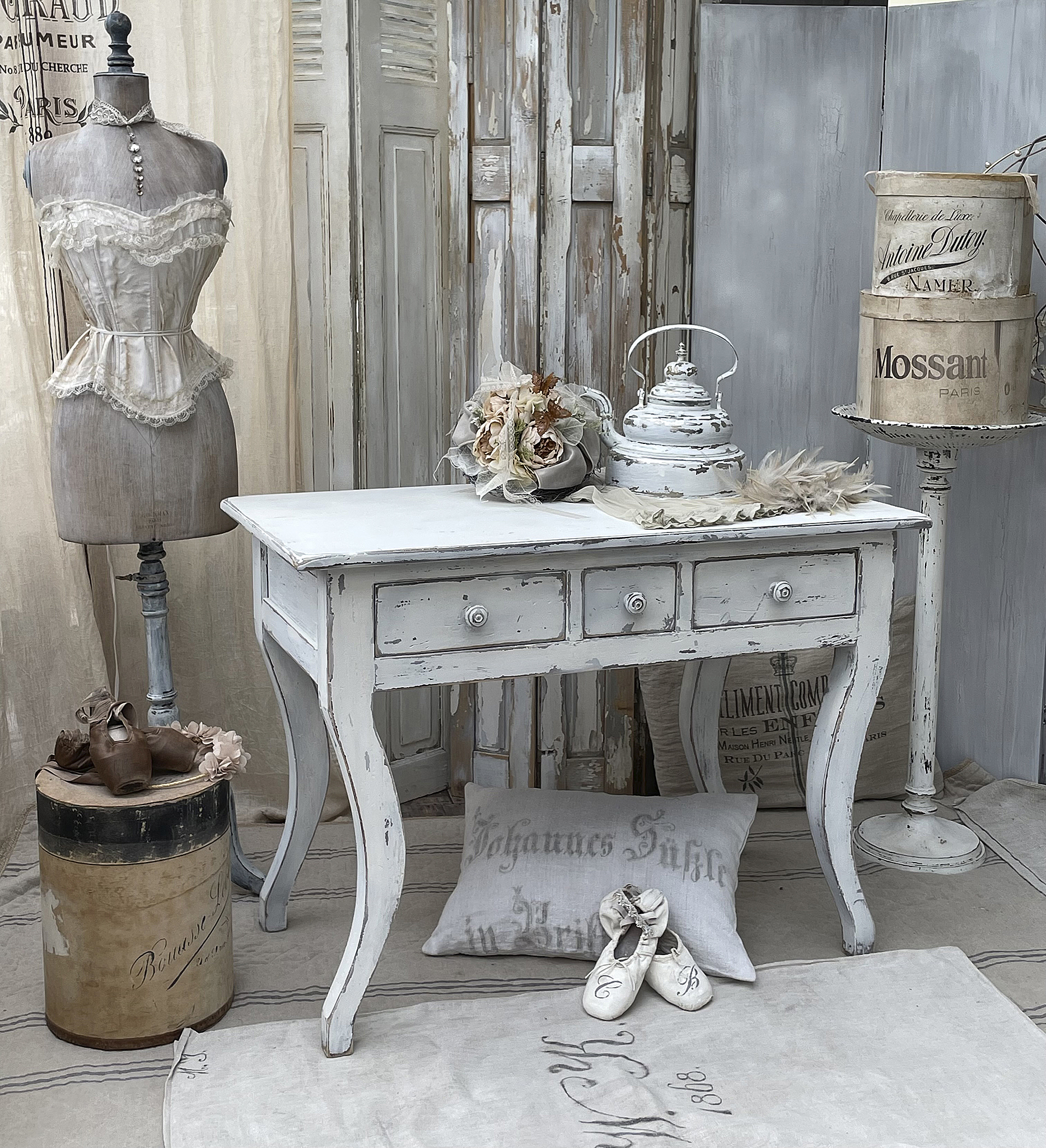Vintage Tisch im Shabby Chic Stil mit Dekoration Ein eleganter weißer Tisch im Shabby Chic Stil, umgeben von antiken Dekorationsartikeln.