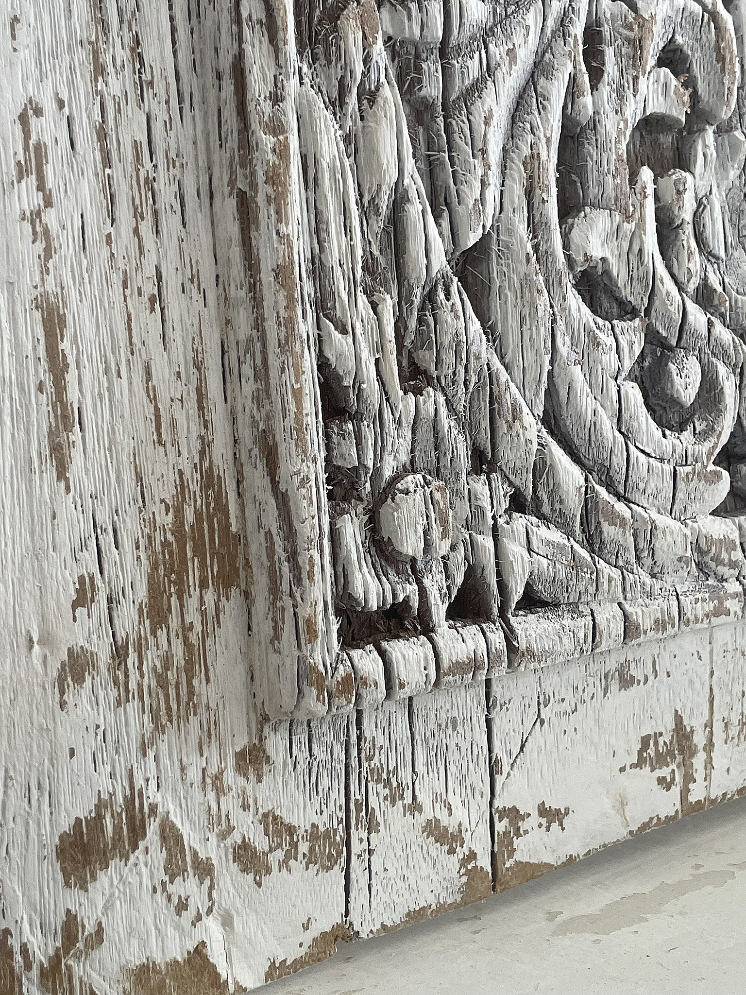 Detailaufnahme eines kunstvoll geschnitzten Holzrahmens in Shabby-Chic-Optik Kunstvoll geschnitzter Holzrahmen mit abgenutzter, weißer Farbe und rustikalem Charakter
