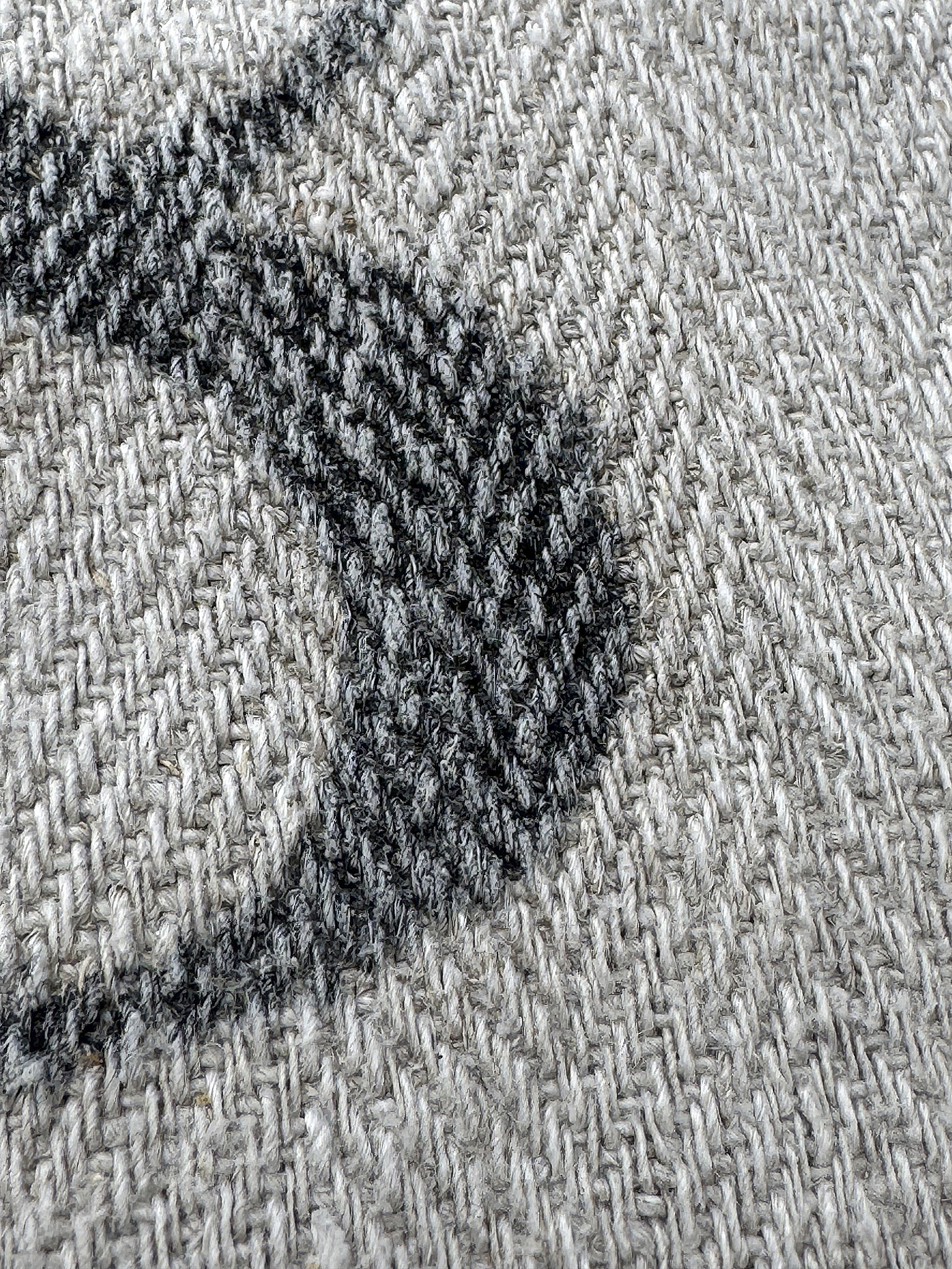 Detailaufnahme eines gestrickten Stoffes in Grau mit einem grafischen Muster Nahaufnahme eines grauen Strickstoffs mit Muster