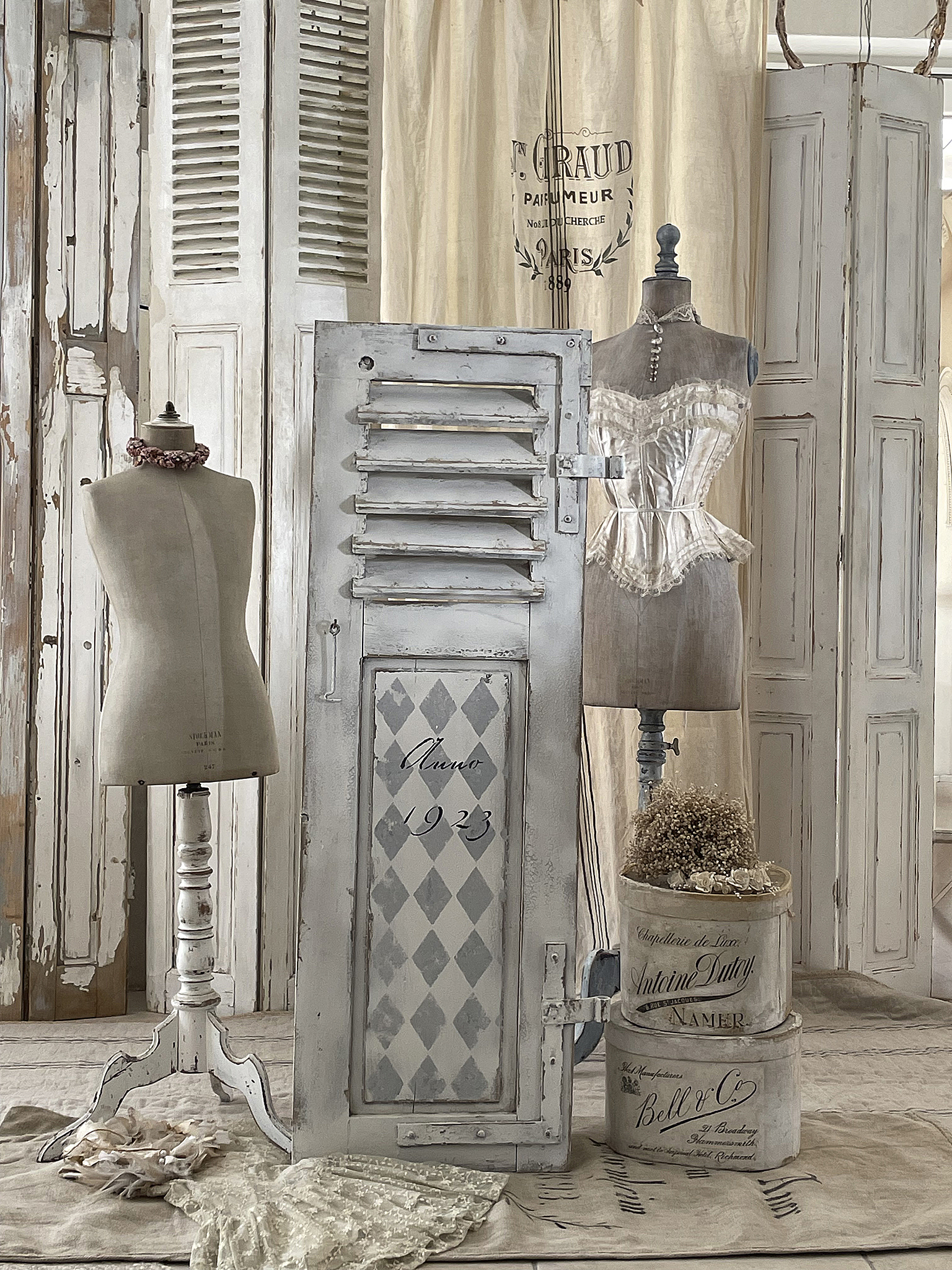 Vintage Dekoration mit modischen Mannequinen und französischen Accessoires Elegante Vintage-Dekoration mit Mannequinen, einer antiken Tür und stilvollen Accessoires in einem gemütlichen Raum.