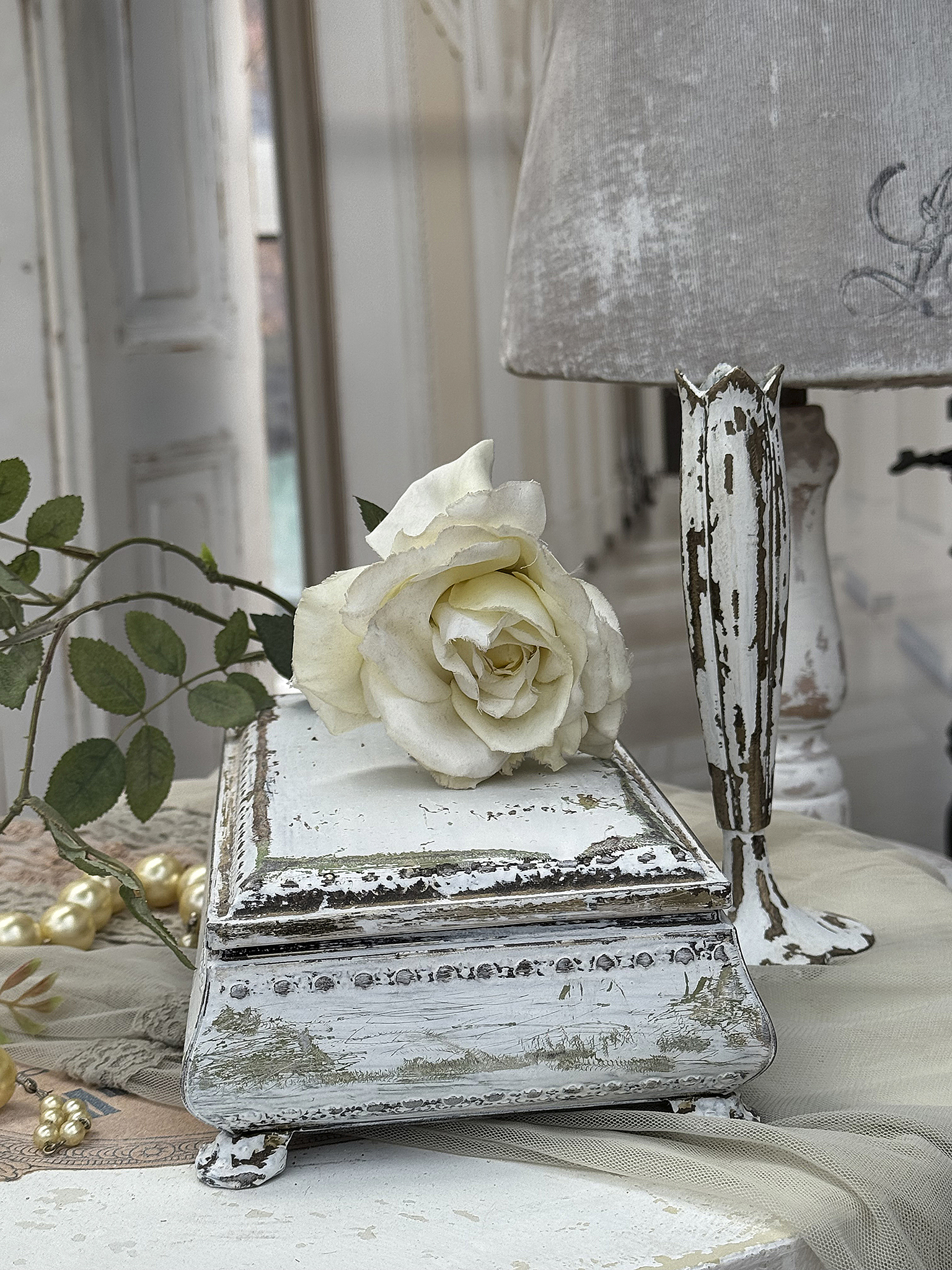 Rustikaler Dekorationsartikel mit einer weißen Rose Dekorative Box mit einer weißen Rose und vintage Lampen im Hintergrund