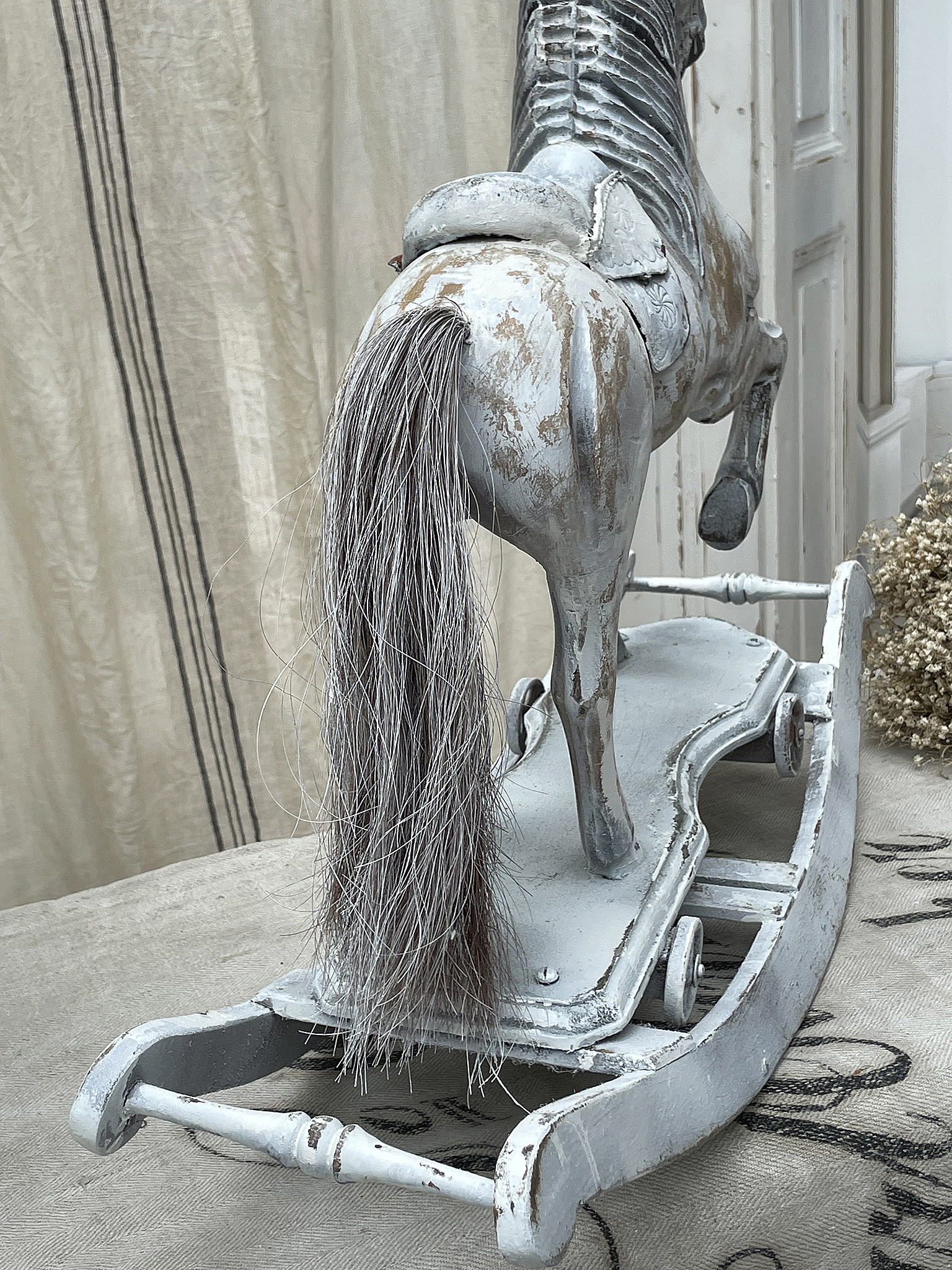 Ein altes, dekoratives Holzrocking-Pferd mit graziler Mähne, im Vintage-Design.