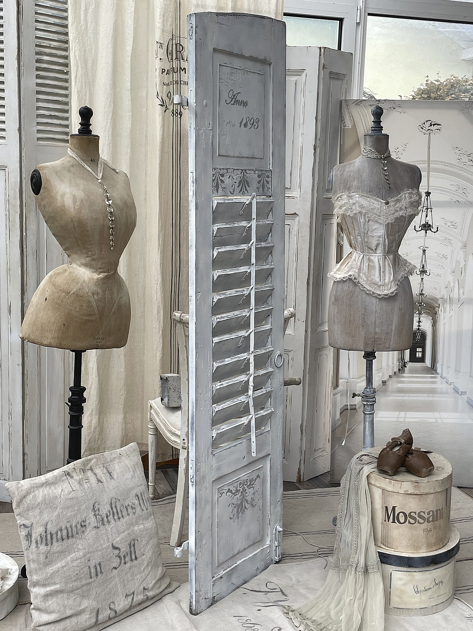 Vintage-Schaufenster mit stilvollen Kleiderpuppen und Wohnaccessoires Bild eines eleganten Vintage-Schaufensters mit Kleiderpuppen und nostalgischen Einrichtungsgegenständen.
