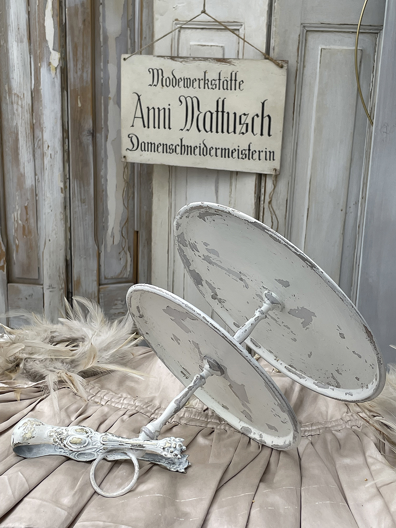 Vintage Schneiderwerkzeug aus der Modewerkstätte Anni Mattusch Ein altes Schneiderwerkzeug und ein Schild der Modewerkstätte Anni Mattusch, ideal für Vintage-Dekoration.