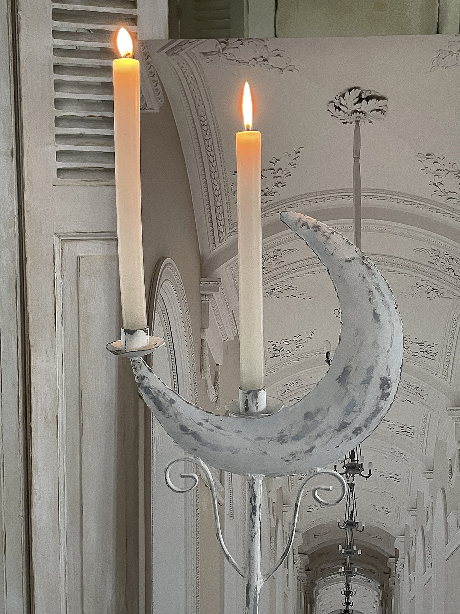 Besonderer Kerzenhalter mit zwei brennenden Kerzen in mondförmigem Design an elegantem Hintergrund