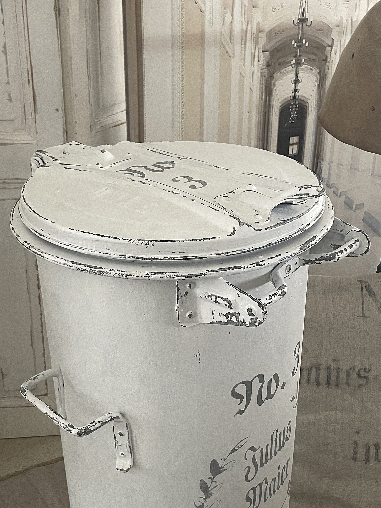 Antiker, weißer Mülleimer mit kunstvollen Verzierungen Weißer Mülleimer mit Vintage-Stil und Beschriftung