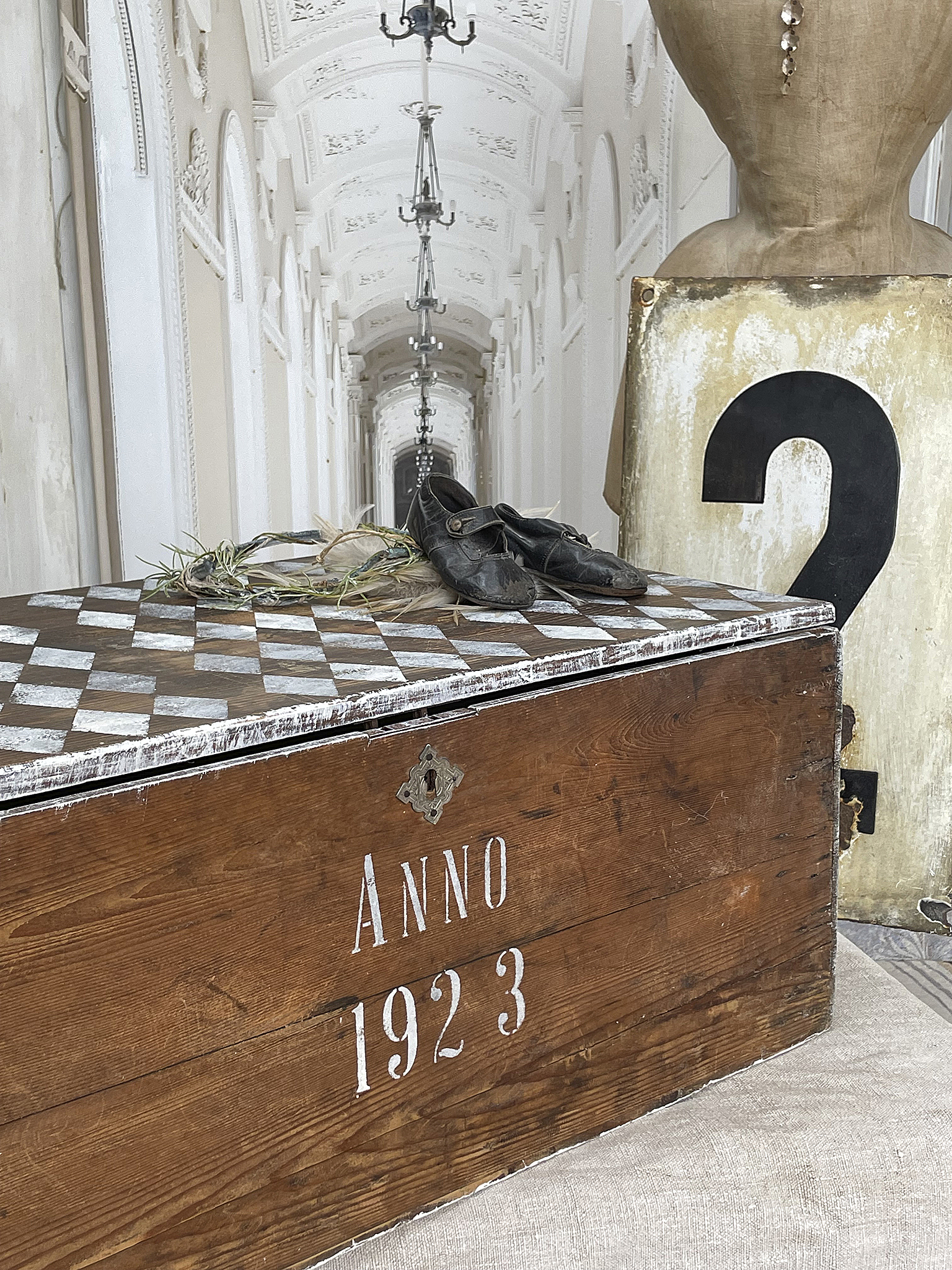 Antike Truhe aus dem Jahr 1923 mit historischen Schuhen Detailansicht einer antiken Truhe mit dem Aufdruck ANNO 1923 und alten Schuhen