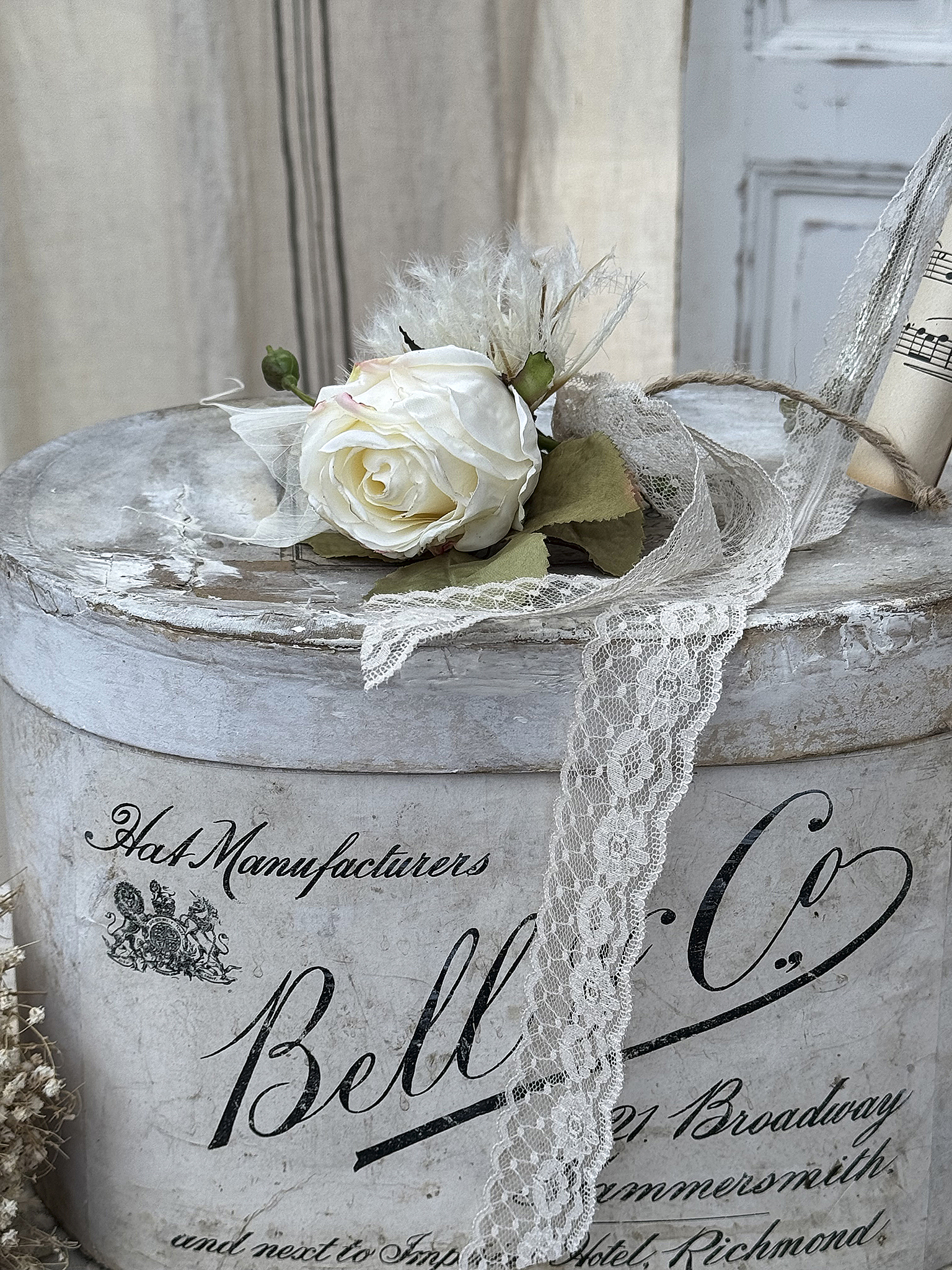 Dekorative Rosenvase mit Spitze auf rustikalem Tisch Weißer Rosenstrauß mit Spitze auf einer vintage Dekobox