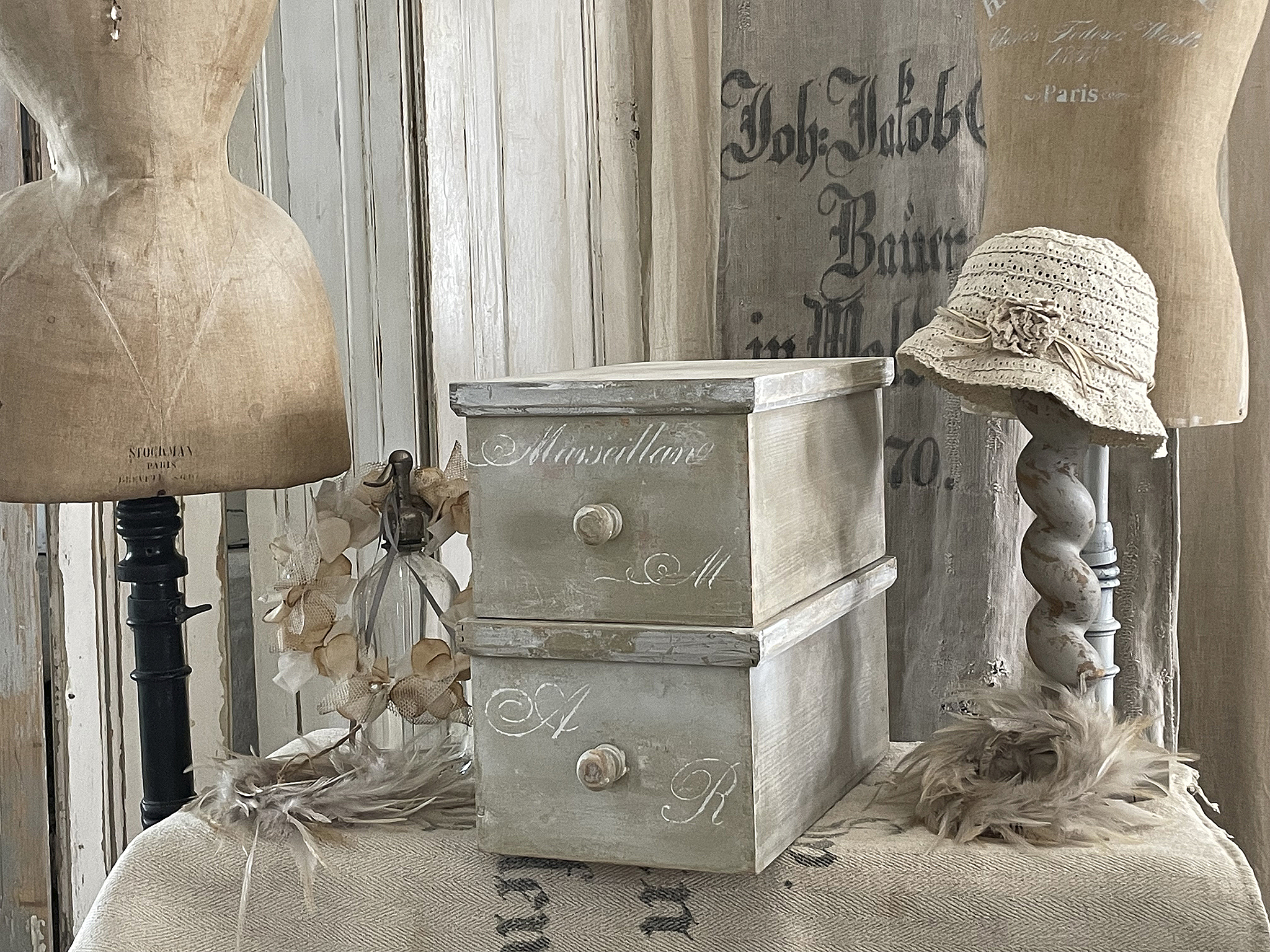Vintage Aufbewahrungskiste mit sentimentaler Gravur Dekorative Vintage Kiste mit stilvollen Details und Hüte auf manuell gestalteten Schaufensterpuppen.