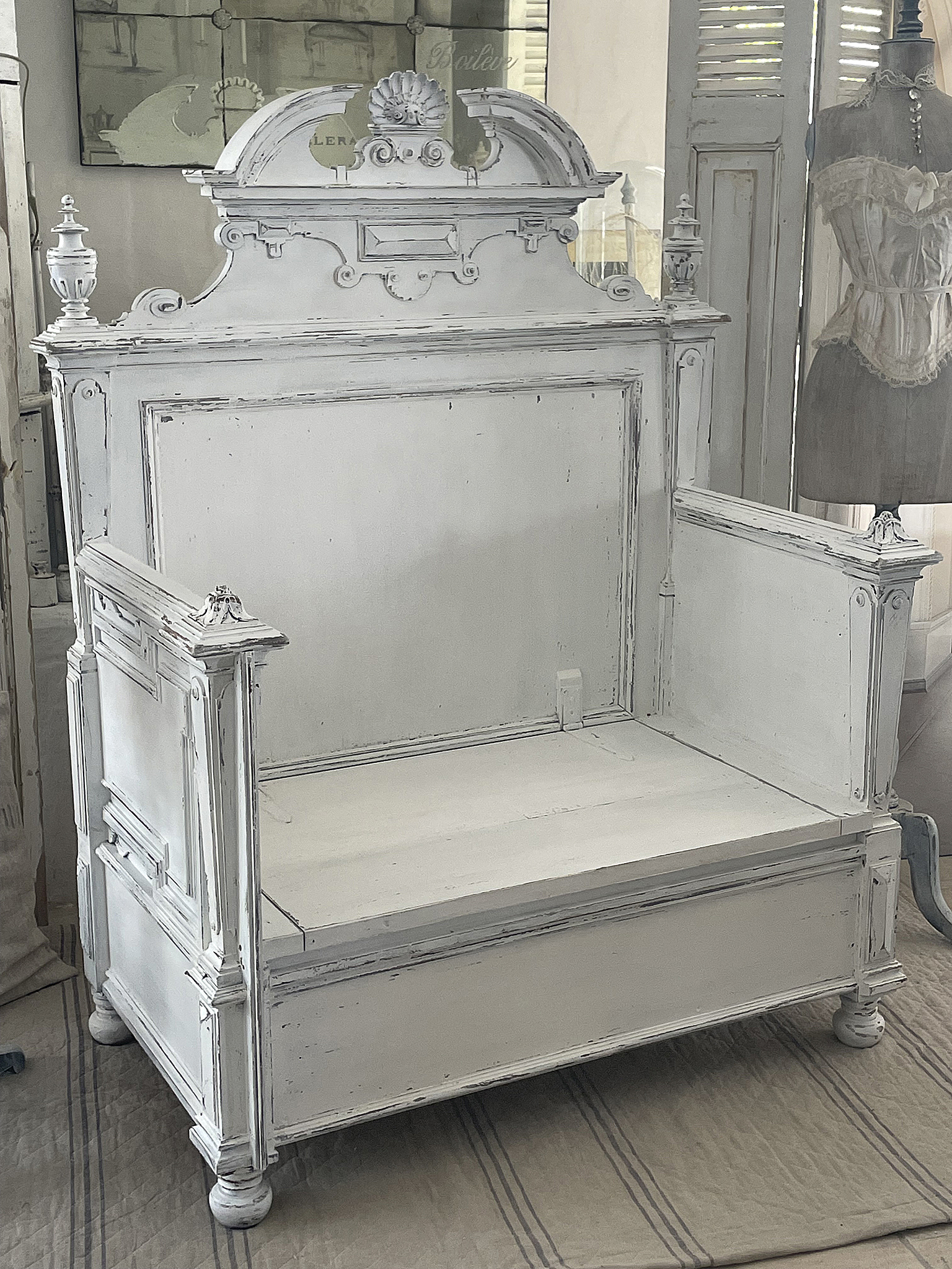 Elegante weiße Sitzbank im Vintage-Stil Vintage weiße Sitzbank mit aufwendigen Details und Verzierungen