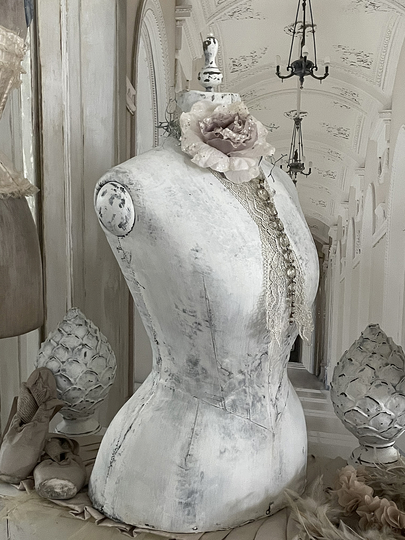 Elegantes Maßschneider-Mannequin mit blumiger Dekoration Schönes Maßschneider-Mannequin verziert mit einer rosa Blume und Spitzenakzenten.