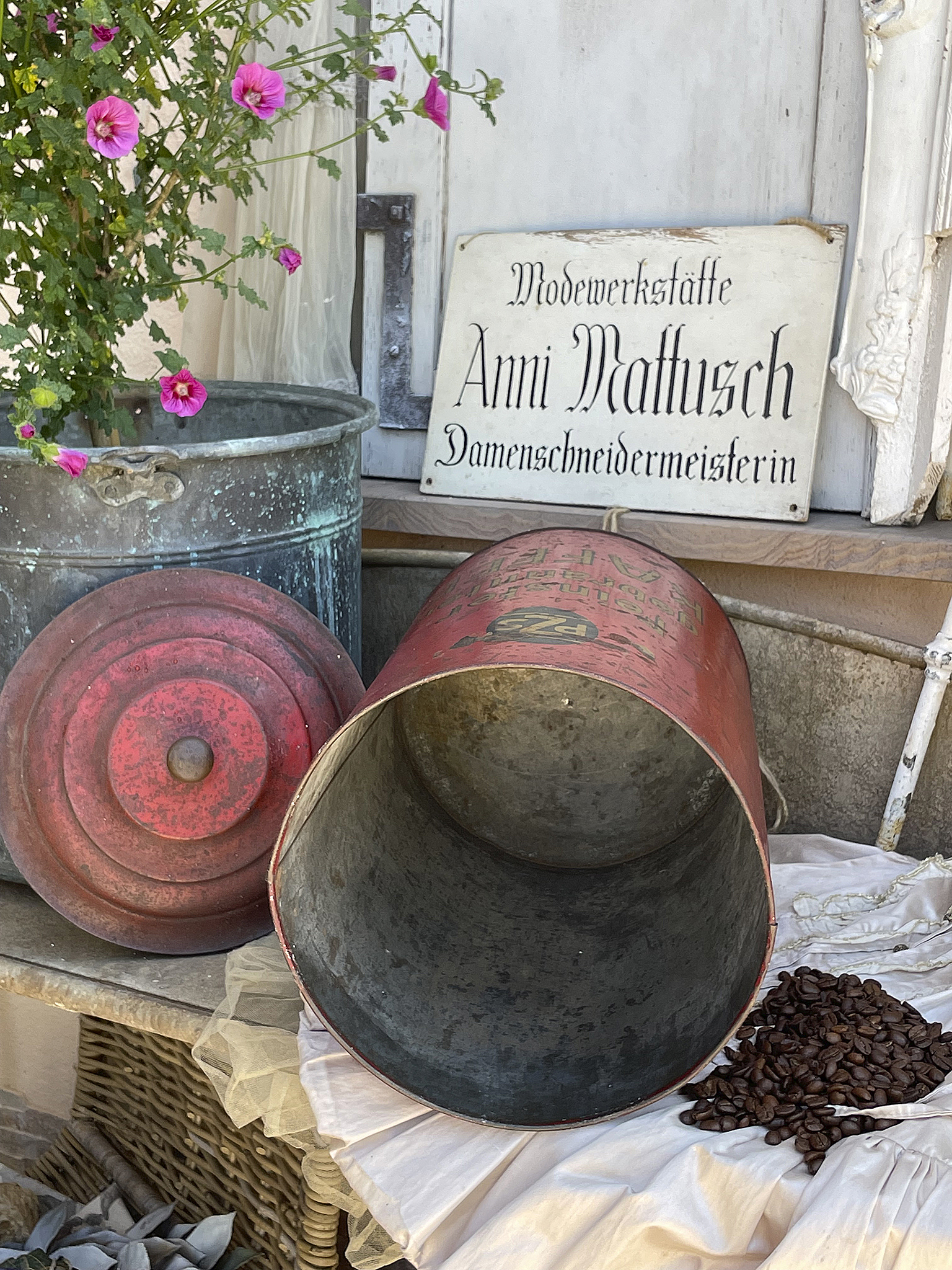 Vintage Deko mit Pflanzen und alten Behältern Alte Behälter und eine Pflanze auf einem Tisch, dekoriert mit Kaffeebohnen und einem Schild.