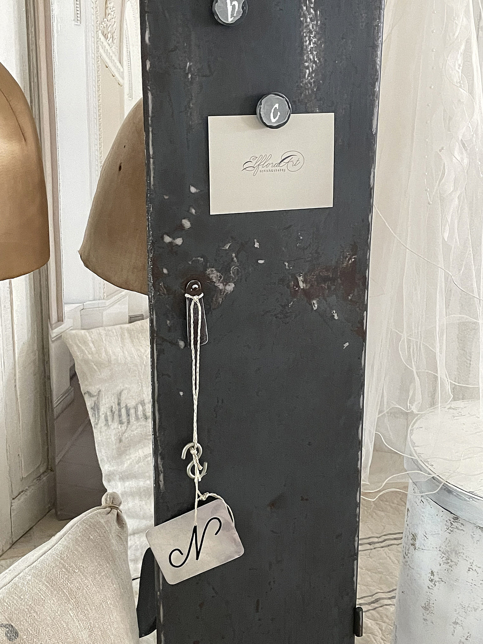 Dekoratives Schild mit Initiale und vintage Stil, moderne Inneneinrichtung Ein elegantes, vintage-inspiriertes Schild mit der Initiale N, kombiniert mit stilvollen Möbelstücken.