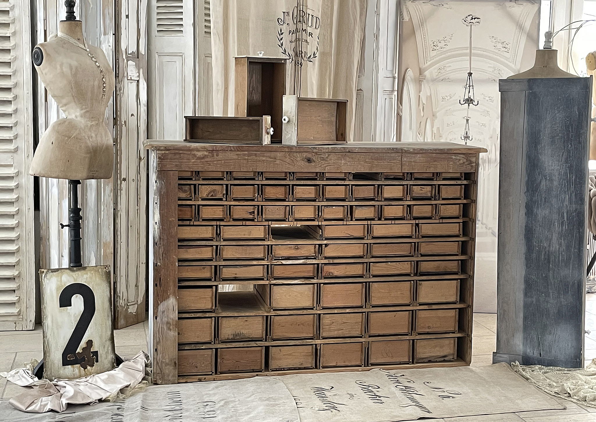 Holzkommode mit vielen Schubladen und Schneiderpuppen im Vintage-Stil
