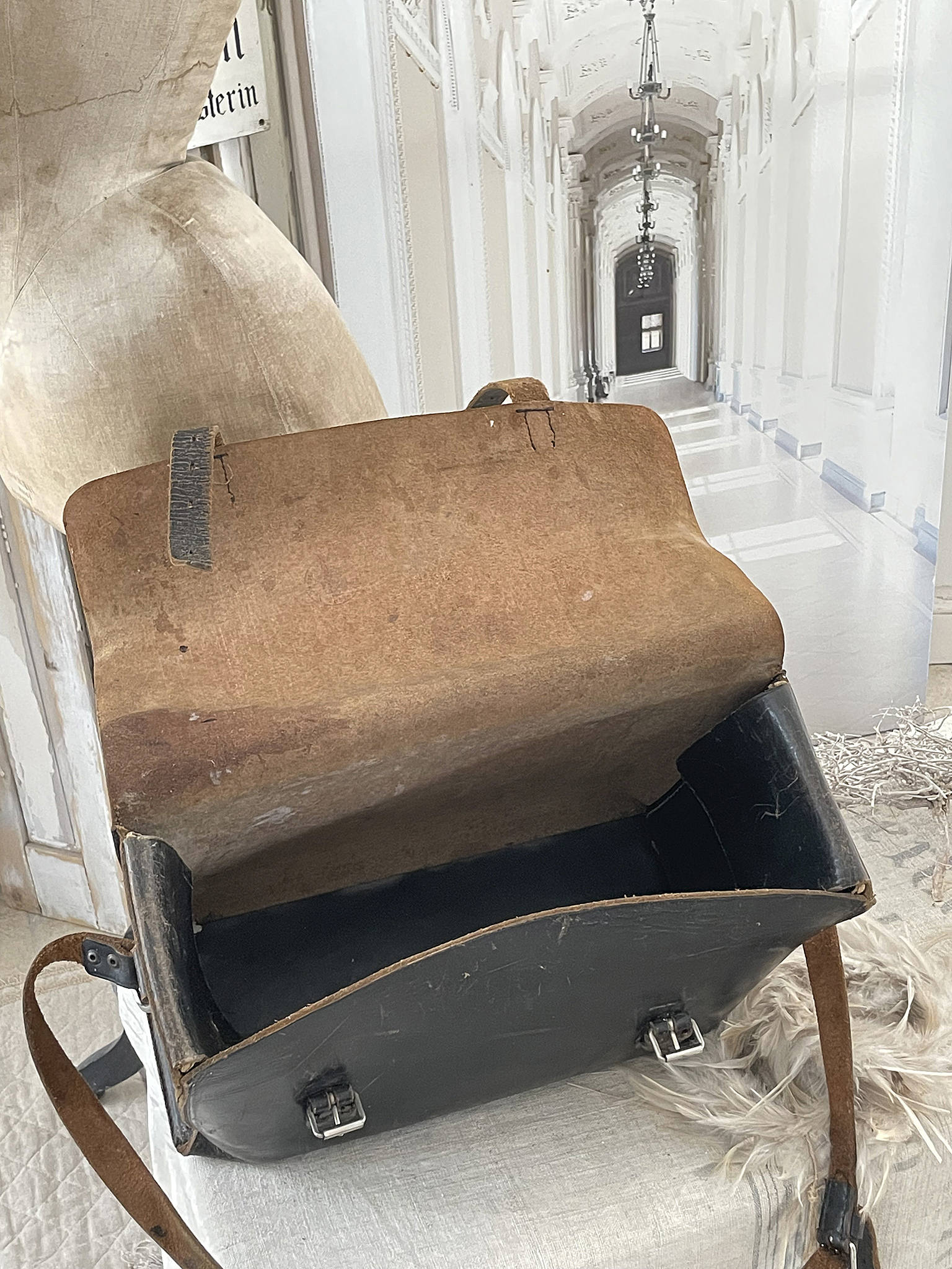Antike Ledertasche mit offenem Deckel und Leerem Innenraum Offene antike Ledertasche auf einem Tisch, Blick auf leeren Innenraum und strukturierten Bezug.