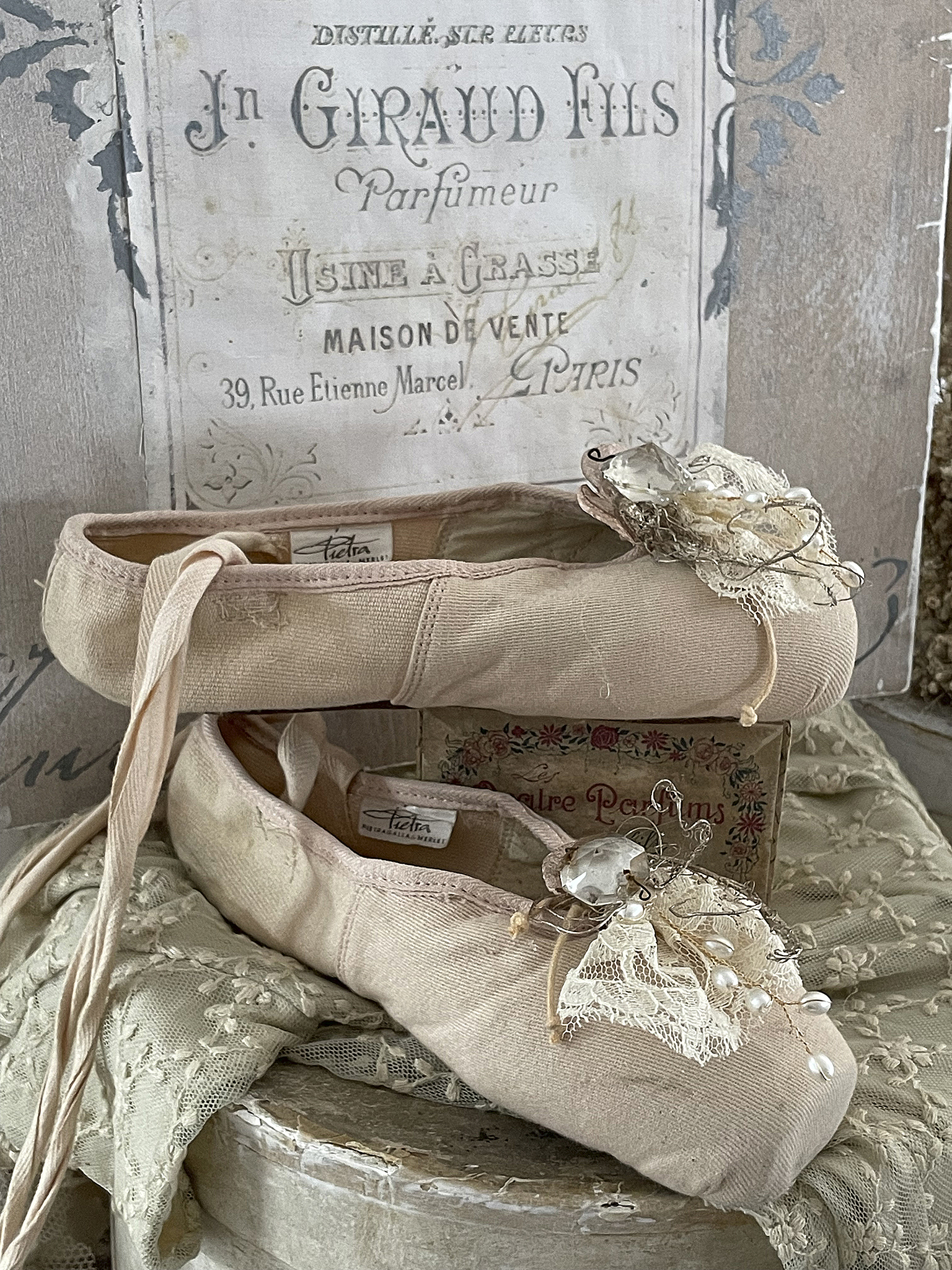 Elegante Ballettschuhe mit dekorativen Details Zwei stilvolle Ballettschuhe mit zarten Verzierungen auf einem Holzuntergrund.